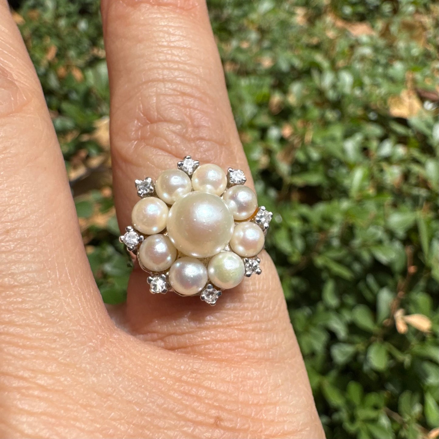 14K gold ring set with a floral cluster of lustrous Pearls in varying sizes, crowned by a central Pearl & surrounded by sparkling Diamond-like accents