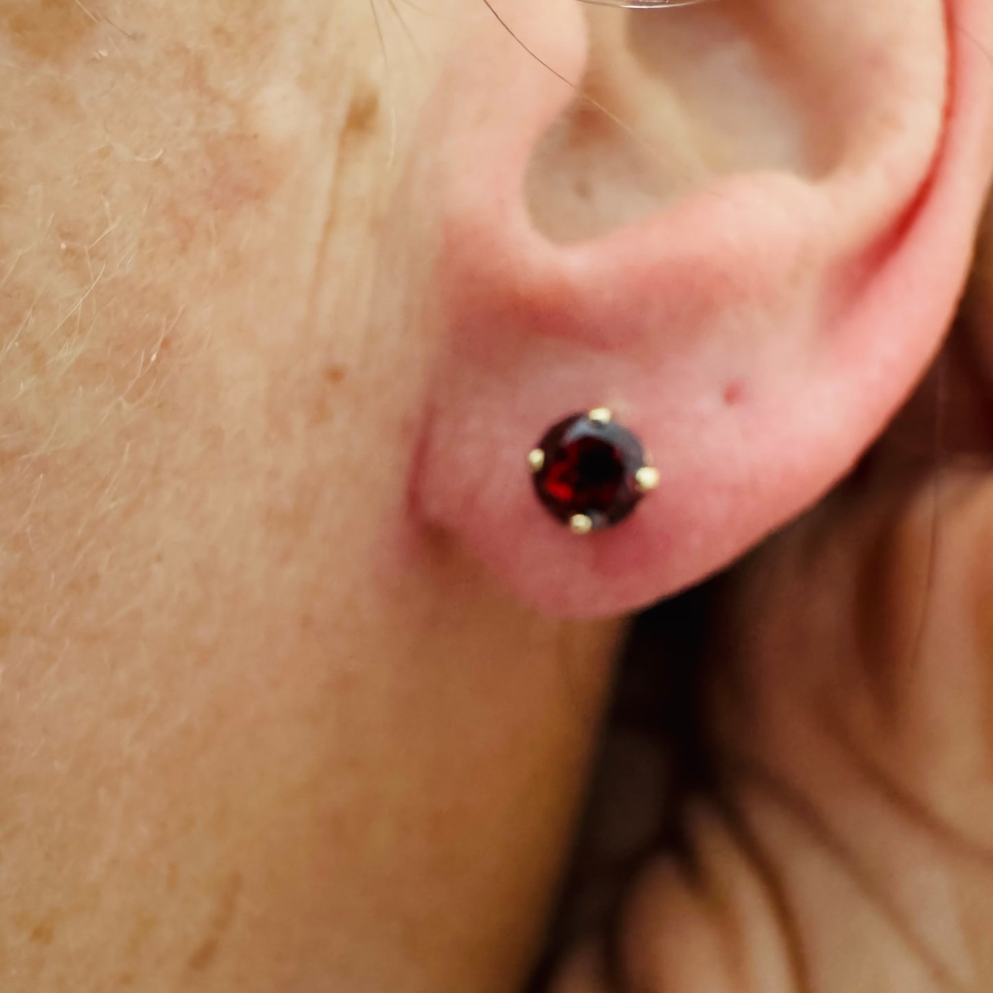 עגילי זהב 14 קראט משובצים אבני גרנט בגוון אדום יין עמוק.