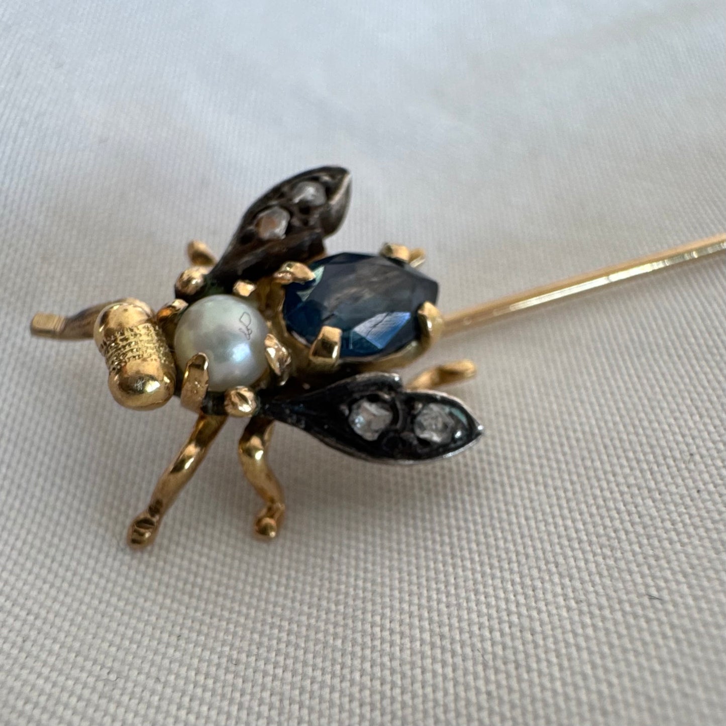 14K gold insect stick pin set with sapphire, seed pearl, and small diamonds.