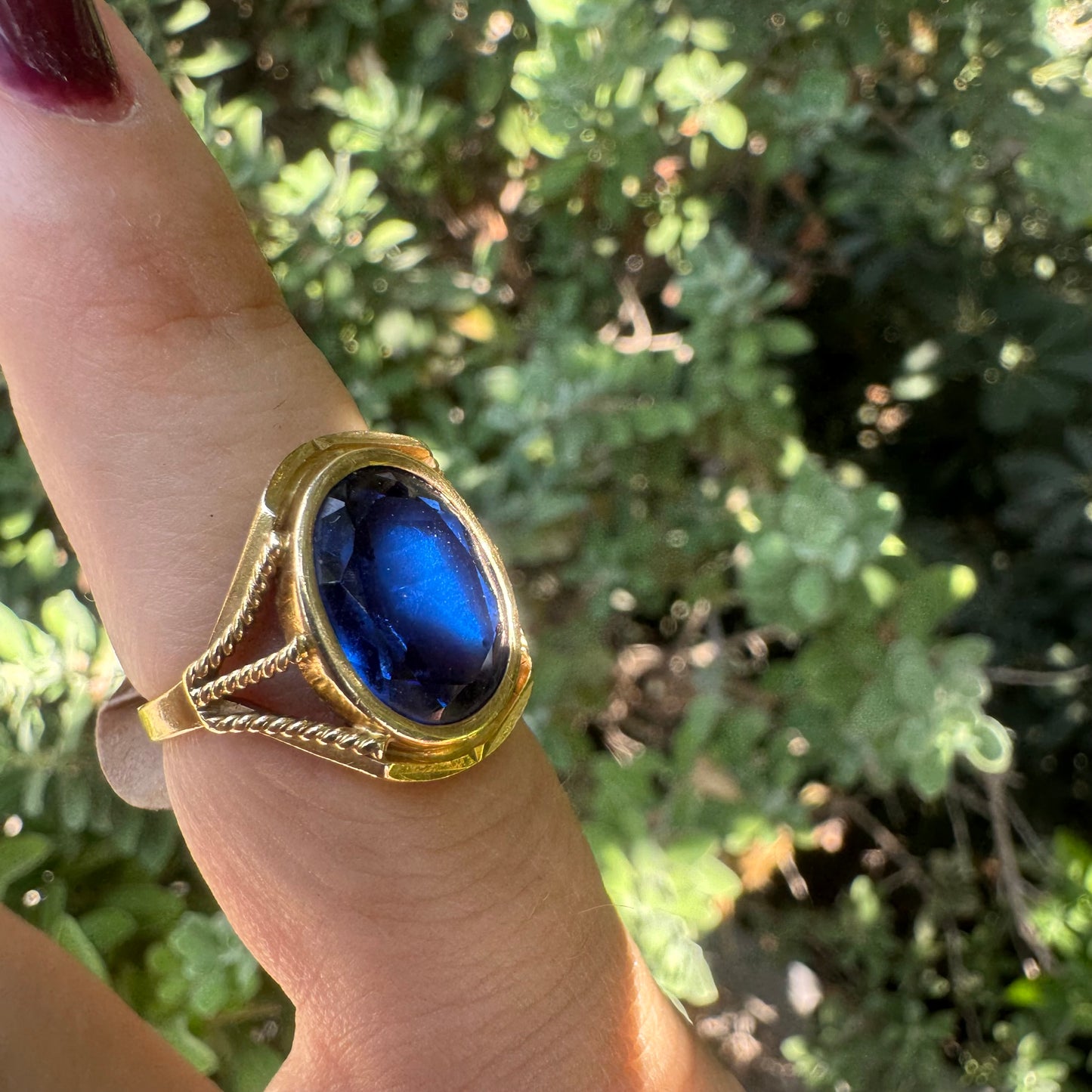 18K yellow gold ring set with a large oval deep blue Sapphire set in an ornate bezel.