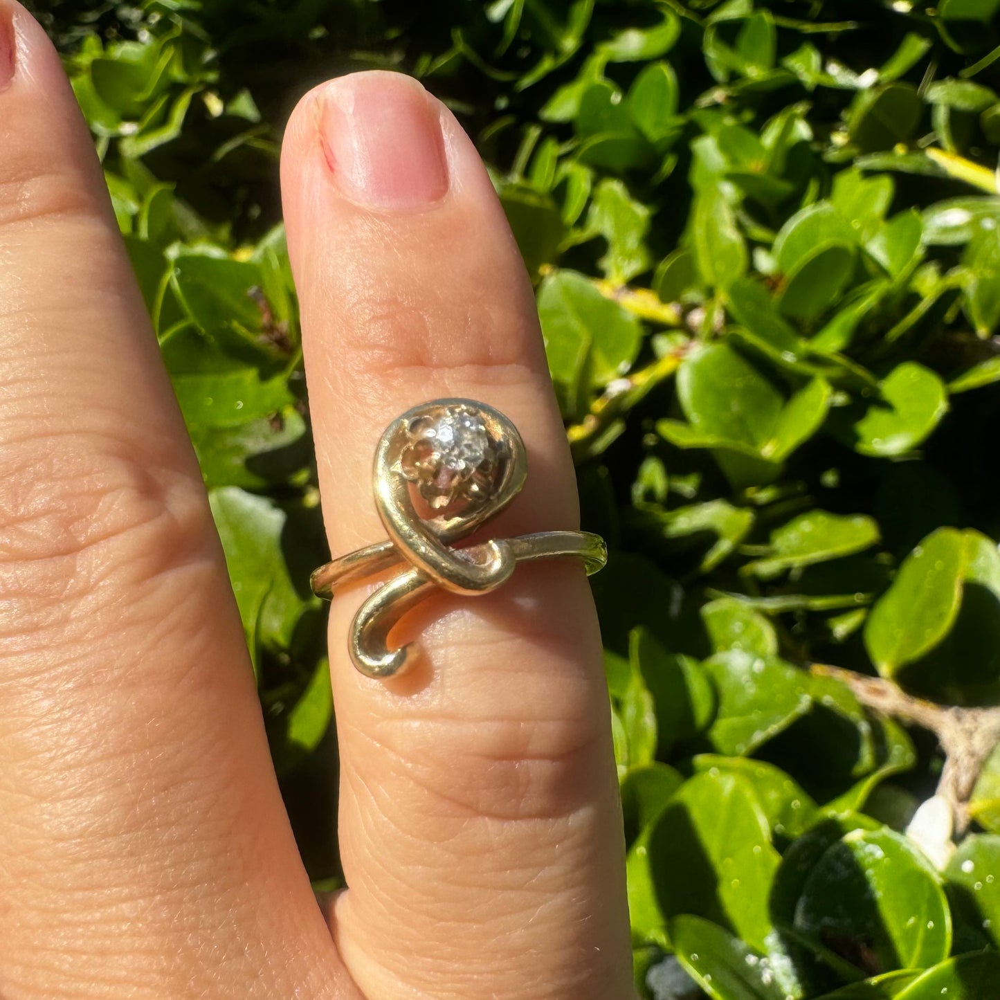 טבעת זהב צהוב 14 קראט משובצת יהלום מרכזי בעיצוב פיסולי וזורם.