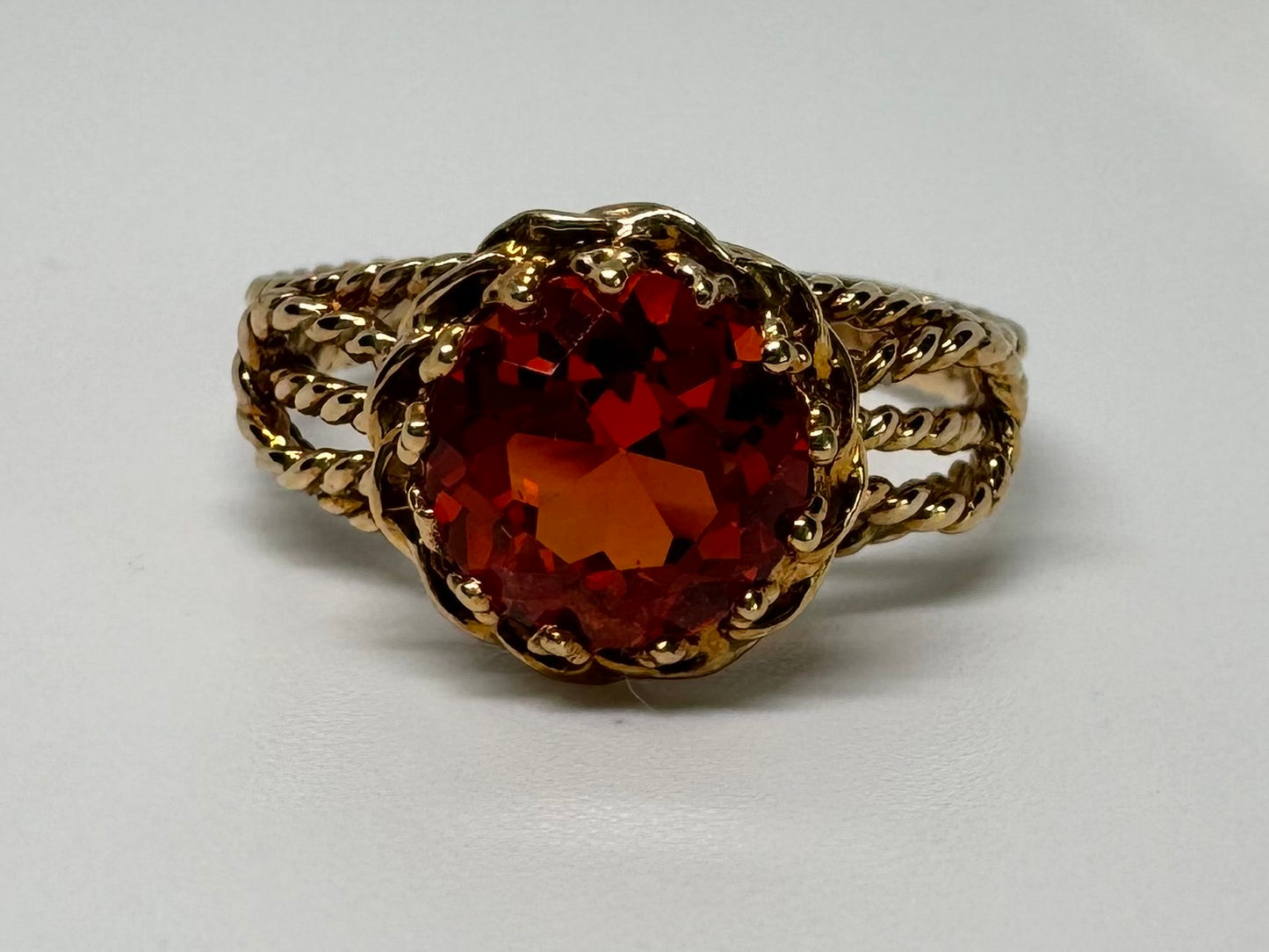 10K gold ring set with a vivid orange gemstone