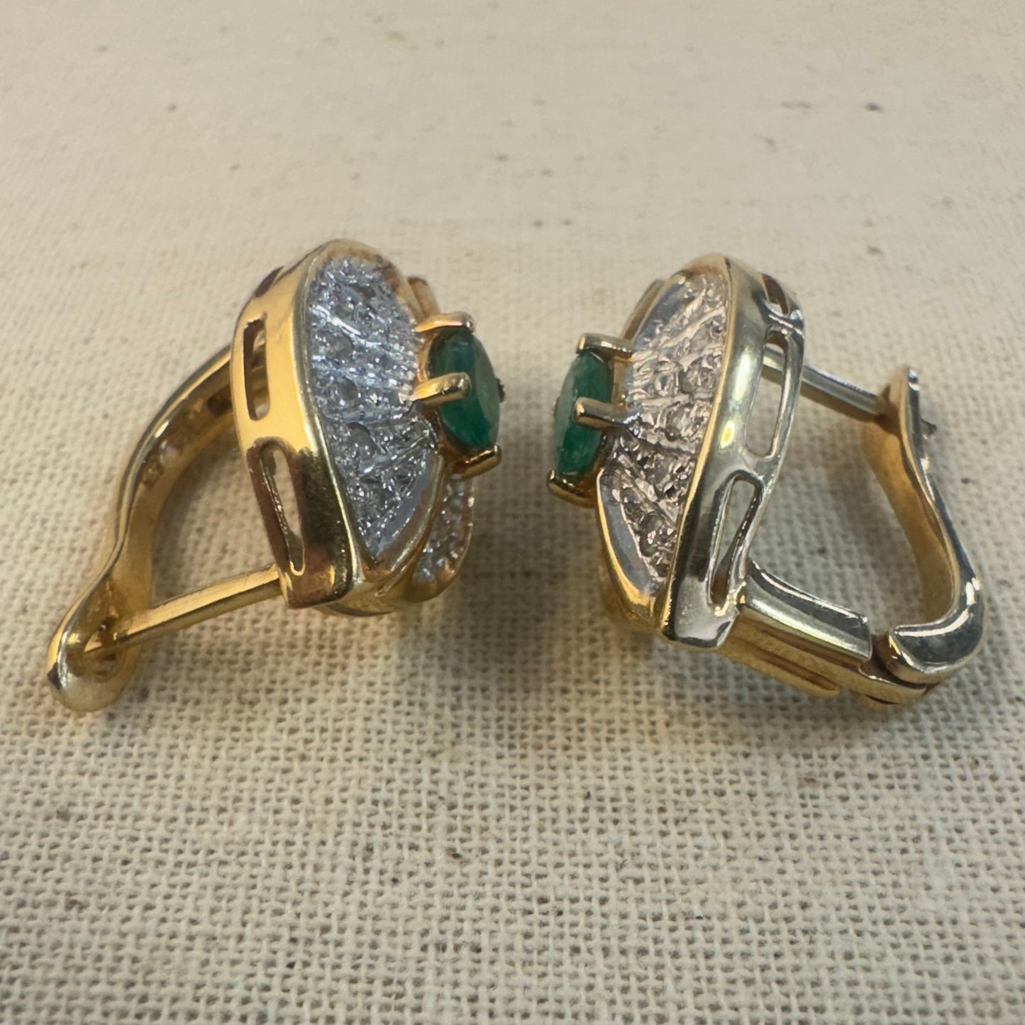 14K gold drop earrings in a refined leaf design, set with vivid green Emeralds at the center and shimmering pavé-set Diamonds along the curves