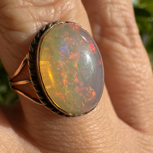 10K gold ring set with a glowing Opal cabochon full of fiery colors
