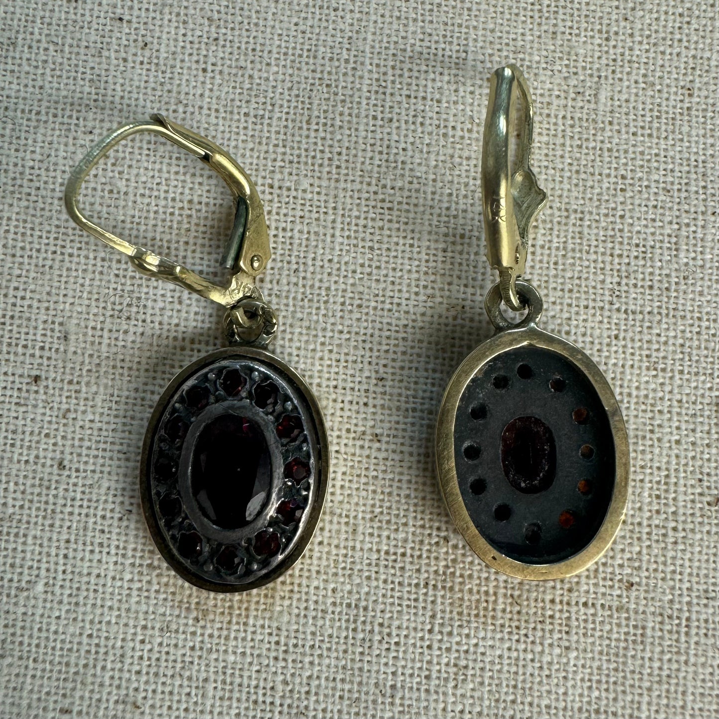 14K gold drop earrings set with deep red oval Garnets surrounded by smaller stones Garnets.