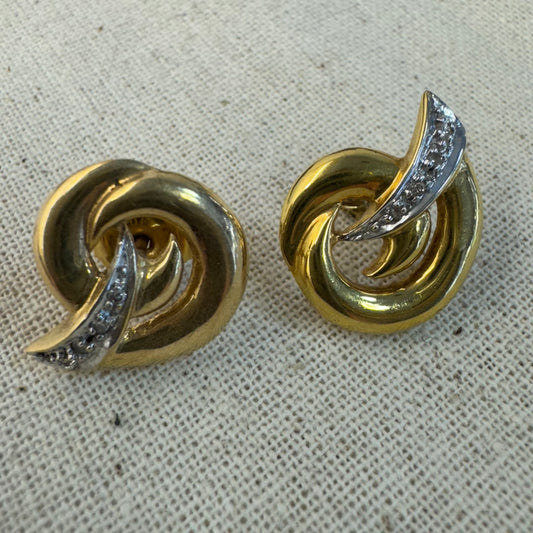 14K gold stud earrings set in a classic knot design, featuring a white gold accent adorned with sparkling Diamonds.