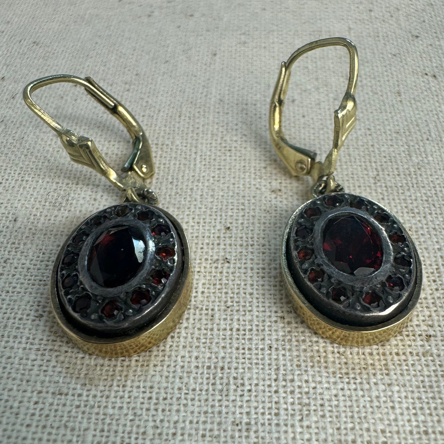 14K gold drop earrings set with deep red oval Garnets surrounded by smaller stones Garnets.