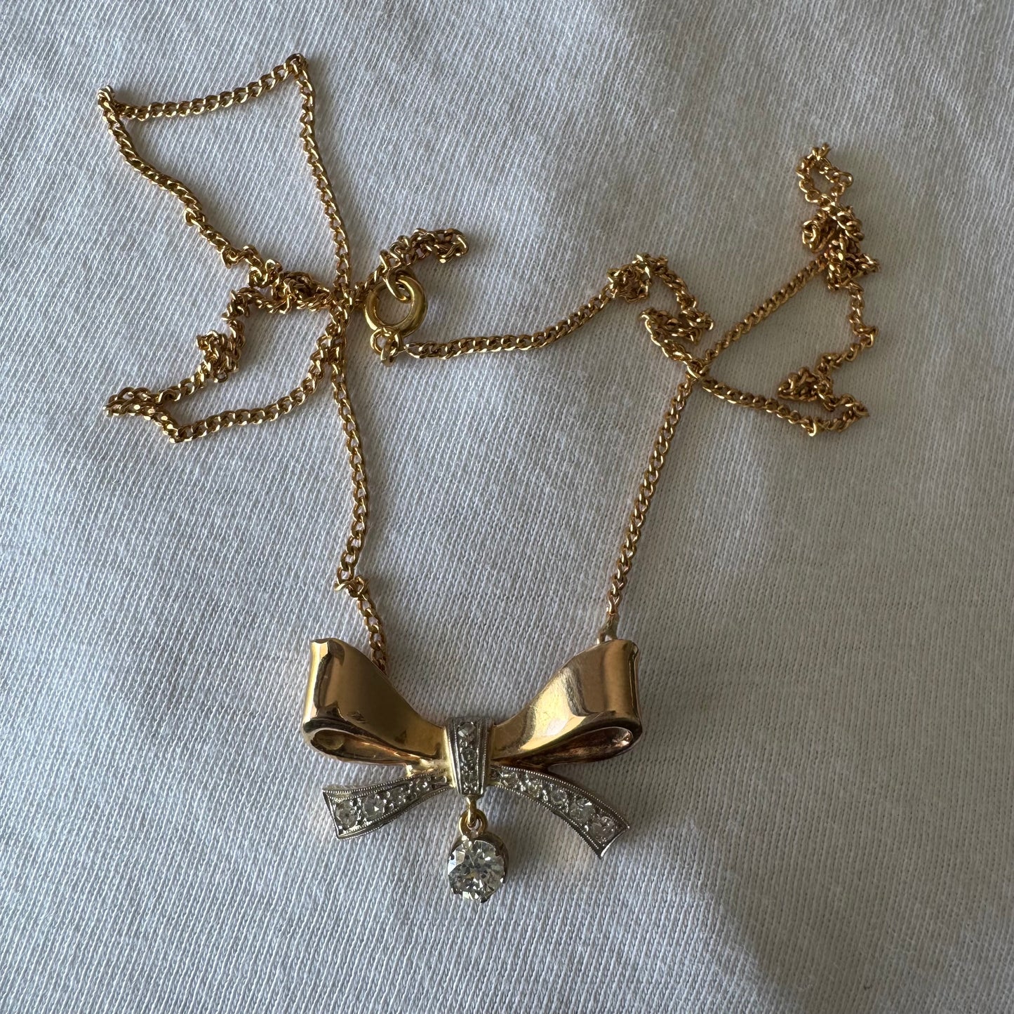 שרשרת זהב 18 קראט עם תליון בצורת סרט קלאסי משובץ יהלומים ונושא יהלום מרכזי תלוי שמוסיף נגיעה של זוהר ואלגנטיות