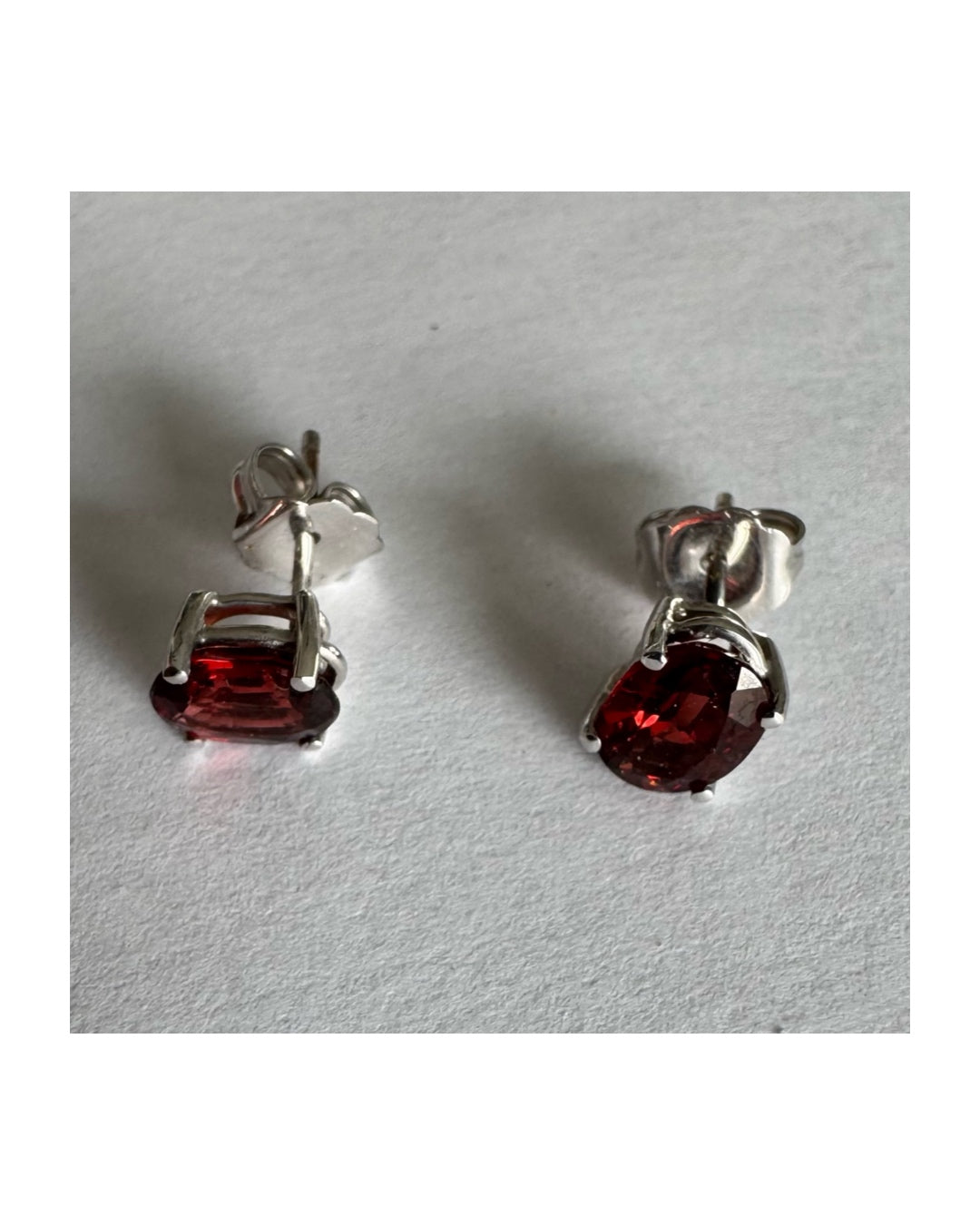 עגילי זהב לבן 14 קראט משובצים אבני גרנט בגוון אדום יין עמוק.