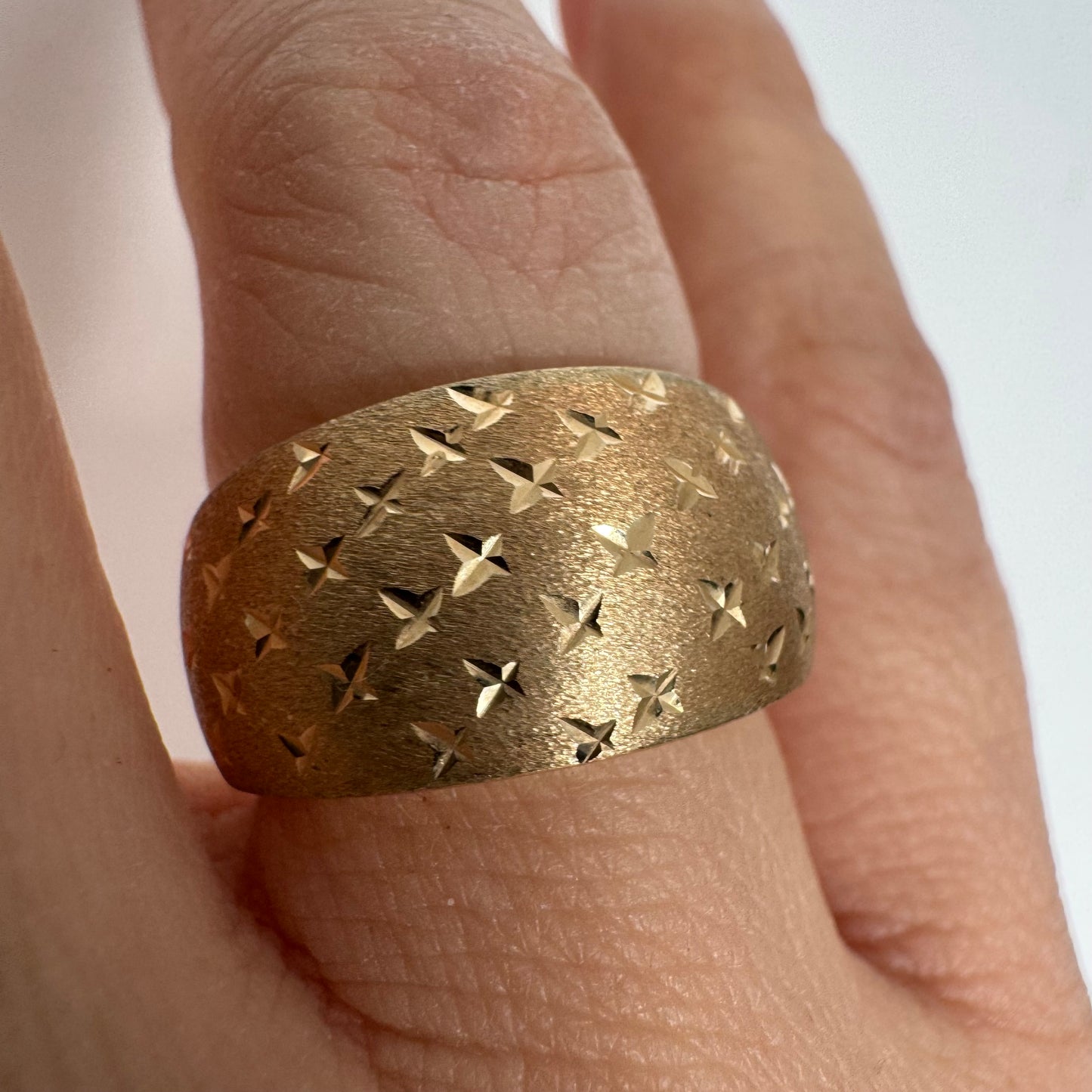 14K gold wide signet-style ring with a matte finish and delicate star engravings.