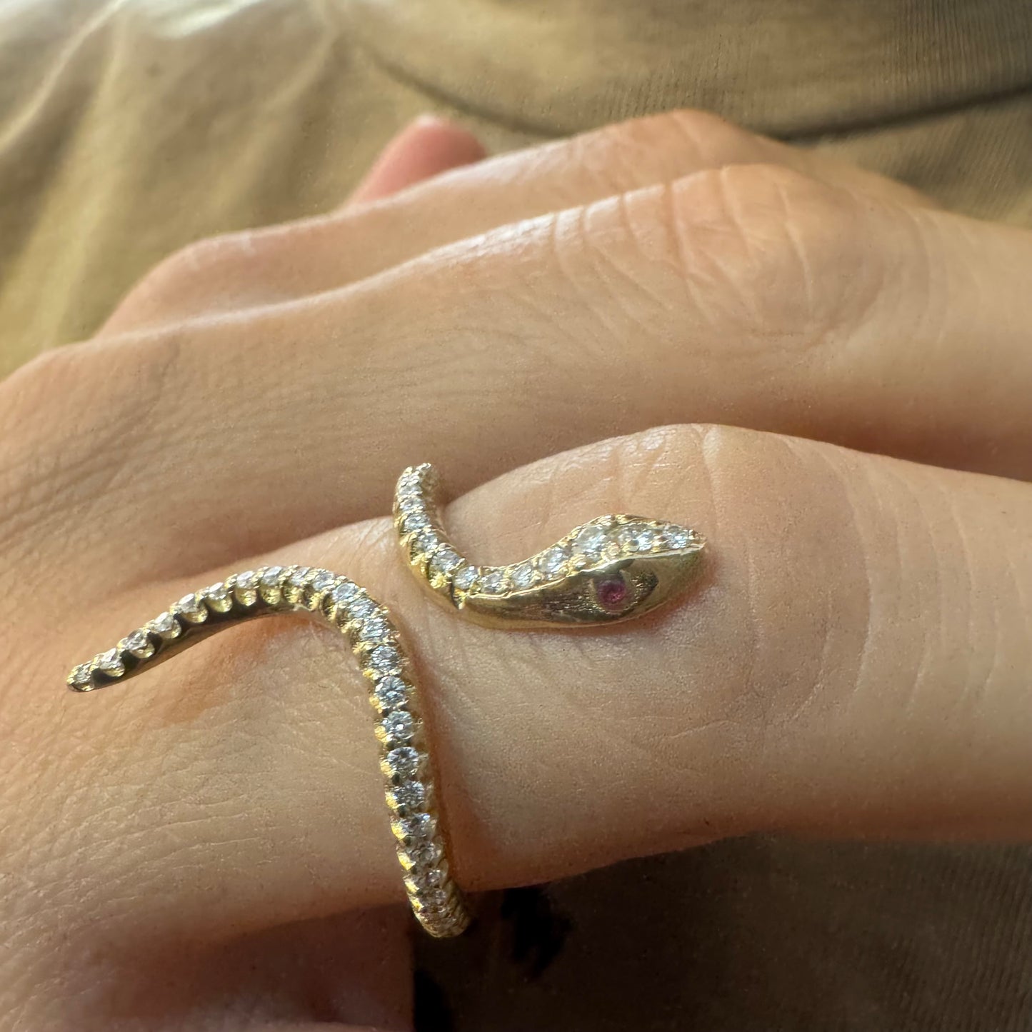 14K gold wrap-around snake ring, fully set with sparkling Diamonds along its body and head, finished with Rubies eyes