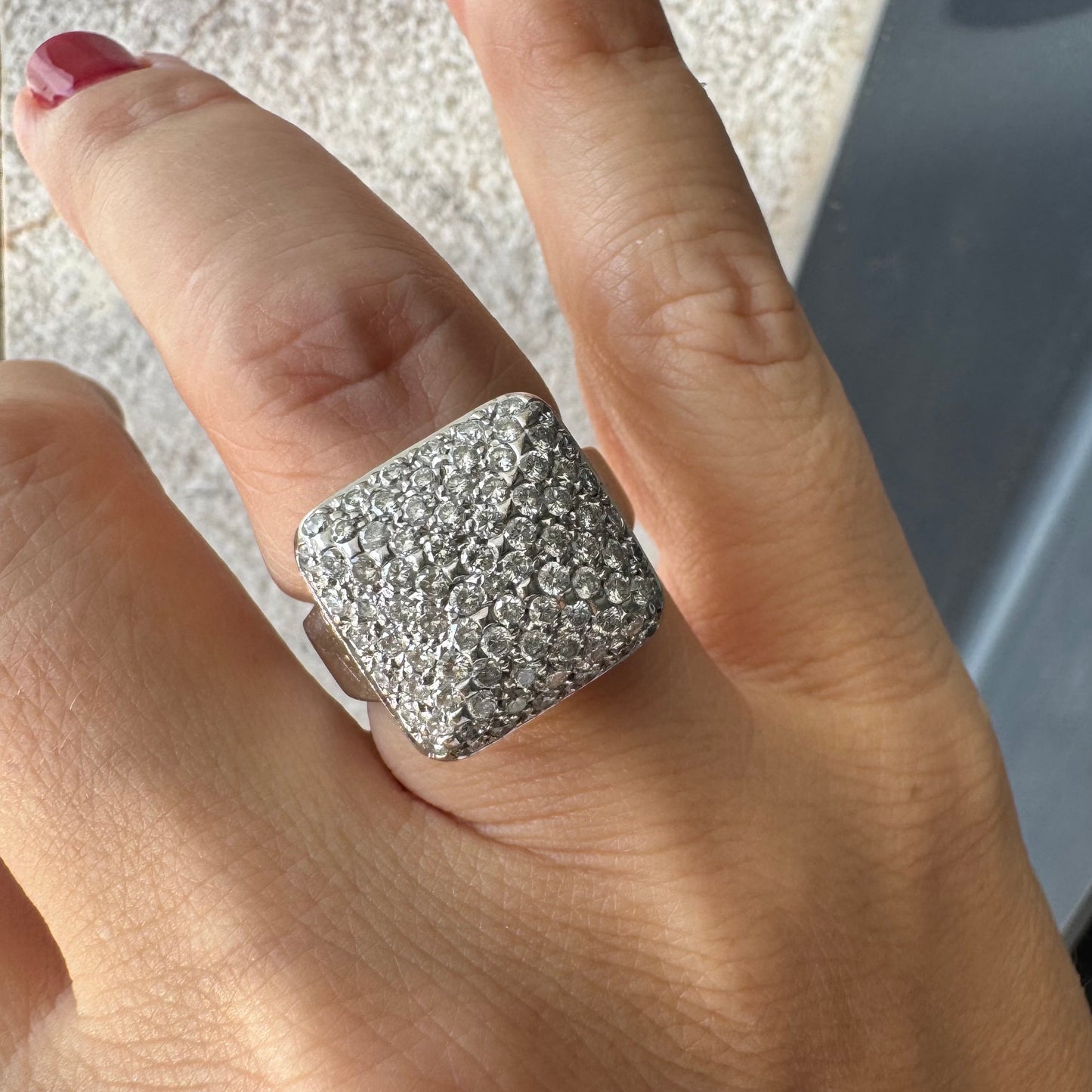 טבעת זהב לבן 18 קראט עם חלק עליון רחב בצורת ריבוע המשובץ כולו ביהלומים מנצנצים, ליצירת מראה יוקרתי ונוצץ.