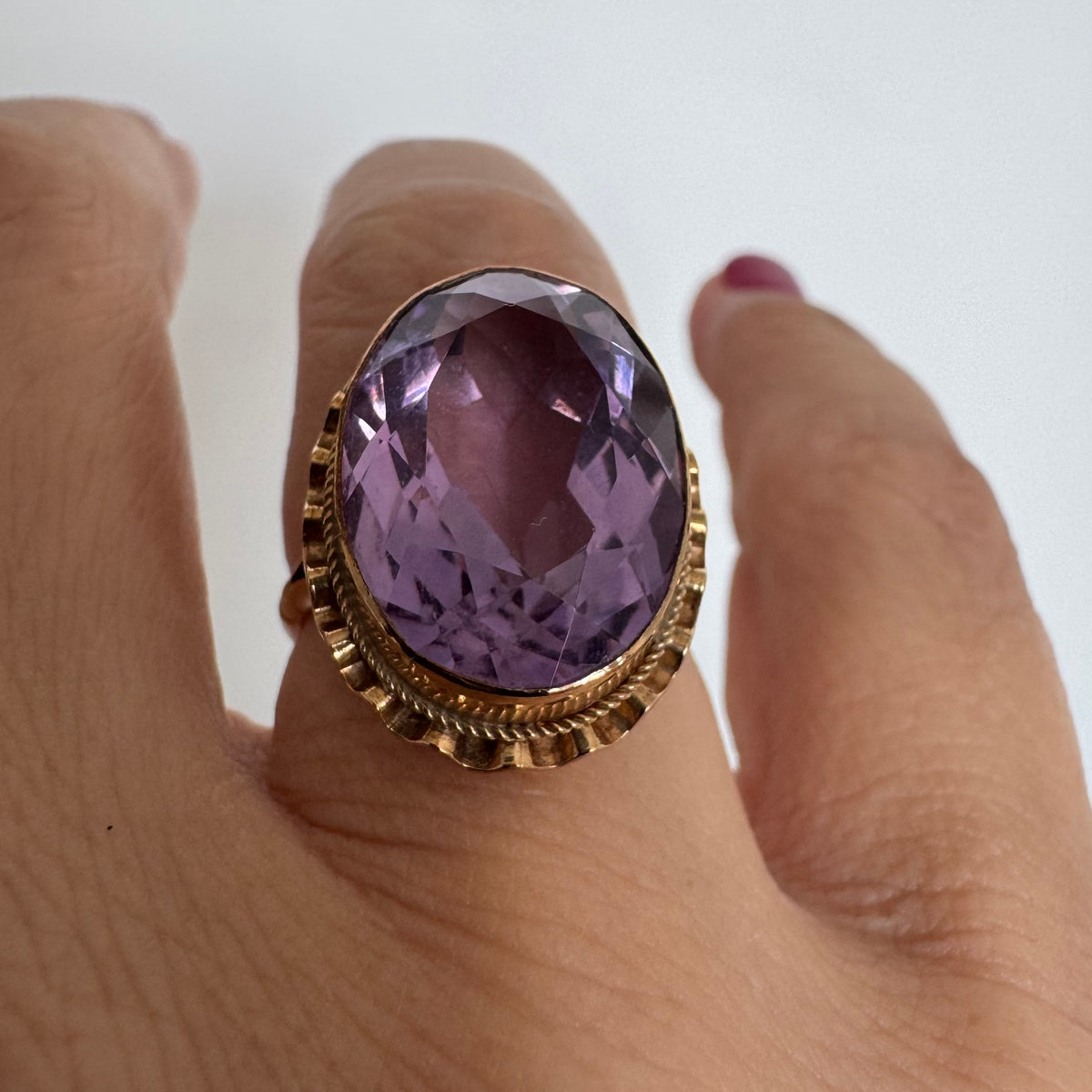 14K gold ring featuring a large oval-cut Amethyst set in an beautifully detailed gold setting