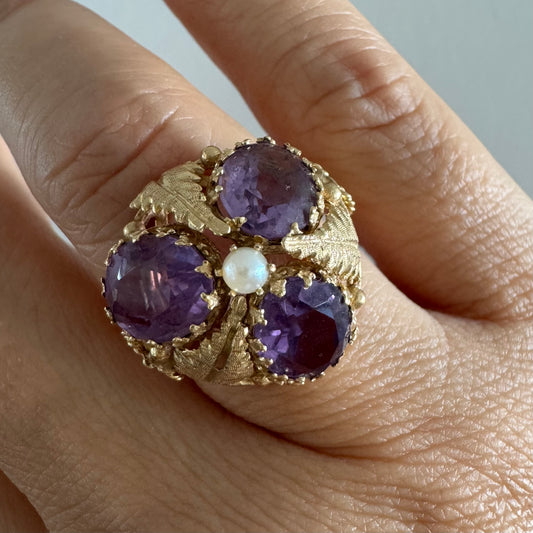 טבעת זהב צהוב 14 קראט משובצת ארבע אבני אמטיסט סגולות בוהקות ופנינה עדינה במרכזה.