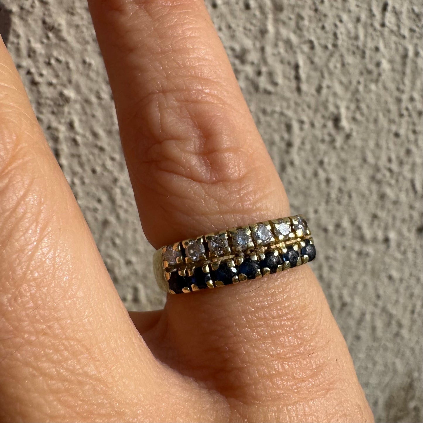 טבעת זהב צהוב 14 קראט, עם שורה של יהלומים נוצצים ושורה נוספת של ספירים כחולים.