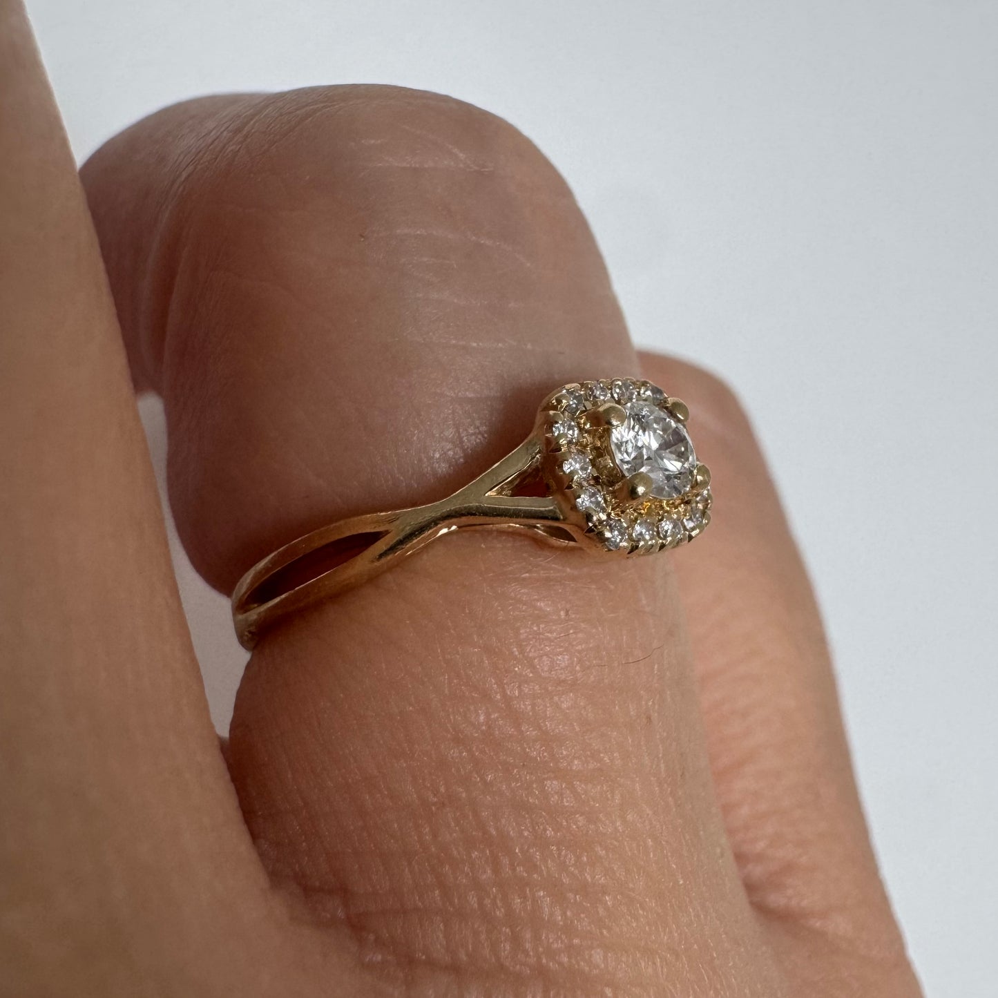 14K gold ring set with a central Diamond surrounded by small Diamonds
