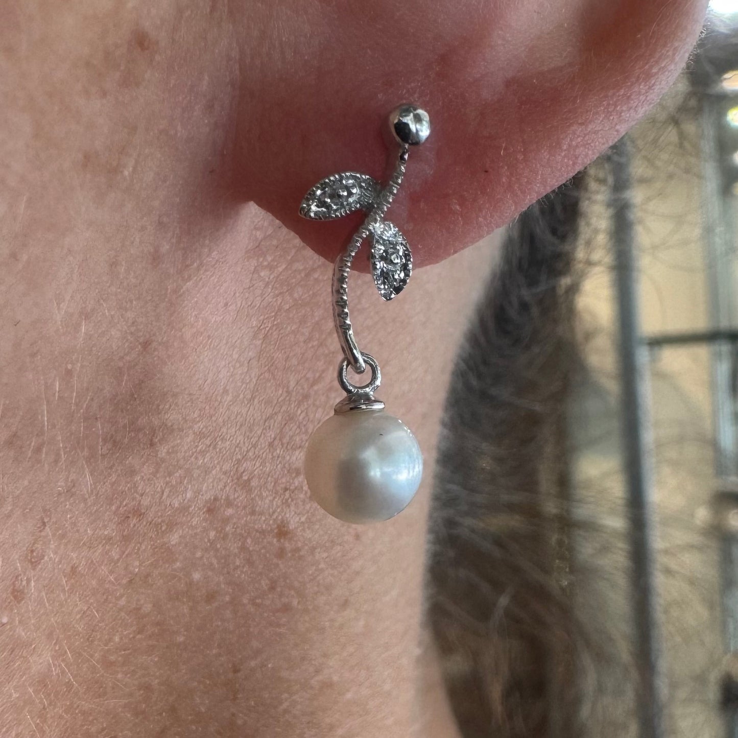 14K gold drop earrings designed with delicate leaf details, each holding a round white Pearl.