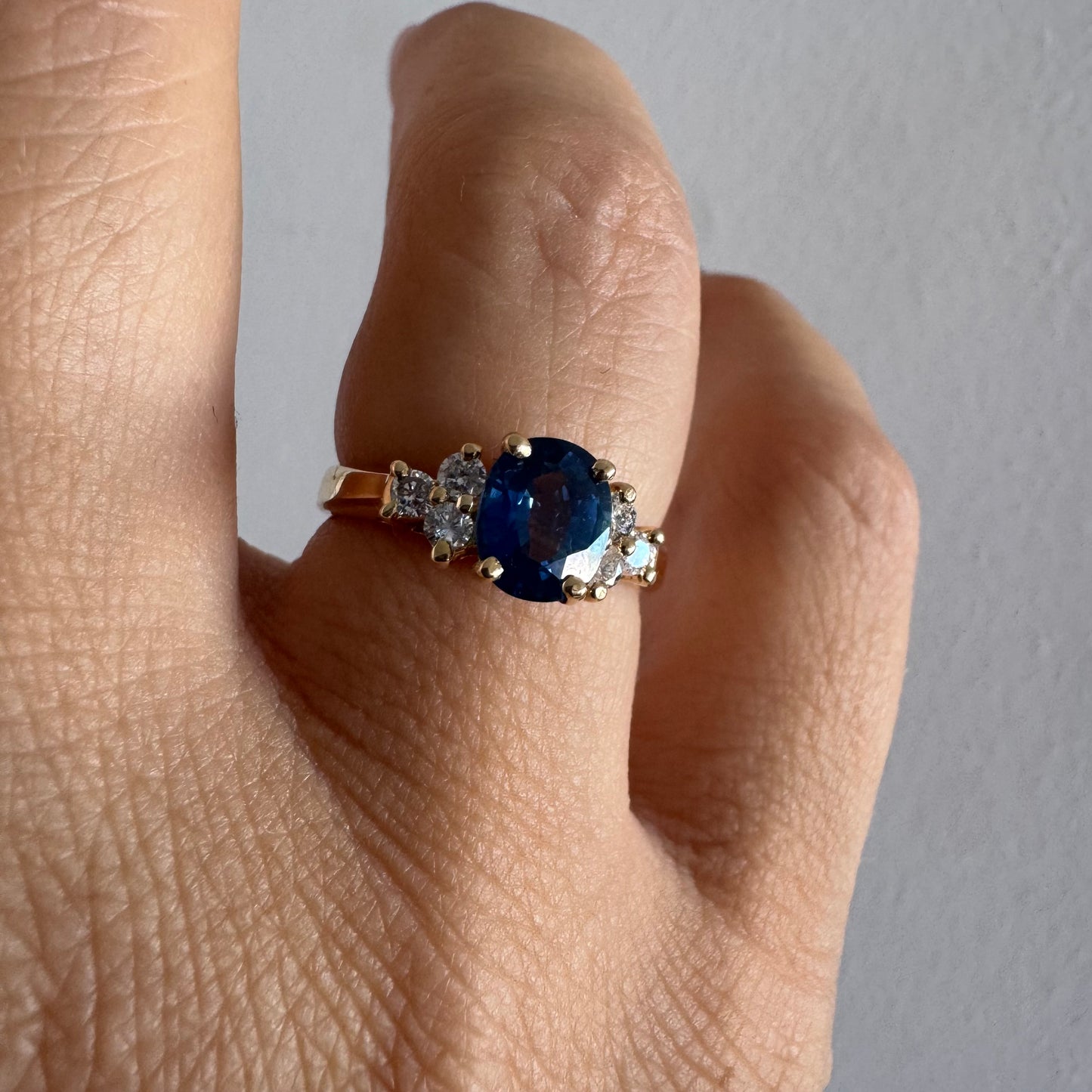14K gold ring set with an oval blue Sapphire at the center & Diamonds