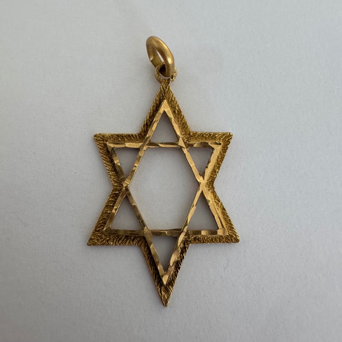 14K gold Star of David pendant with textured detailing and an open design.