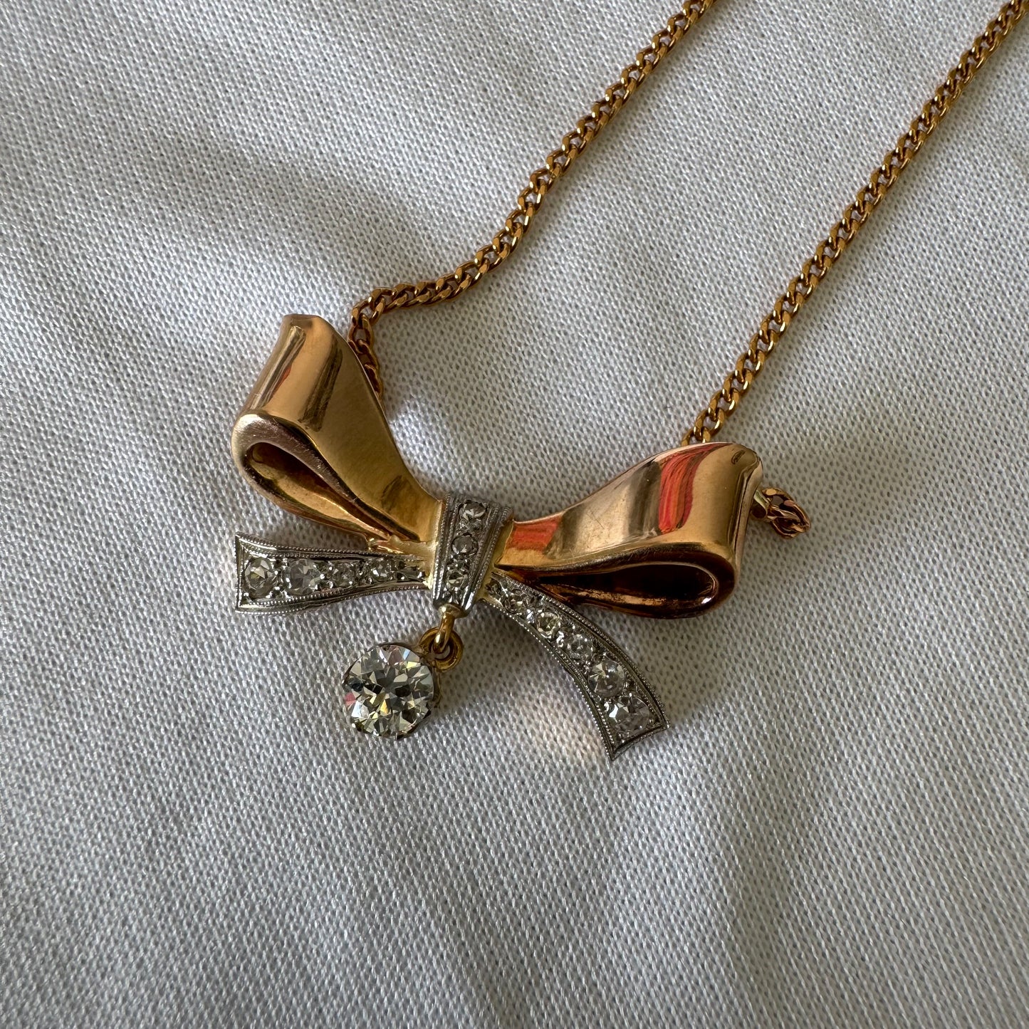 שרשרת זהב 18 קראט עם תליון בצורת סרט קלאסי משובץ יהלומים ונושא יהלום מרכזי תלוי שמוסיף נגיעה של זוהר ואלגנטיות