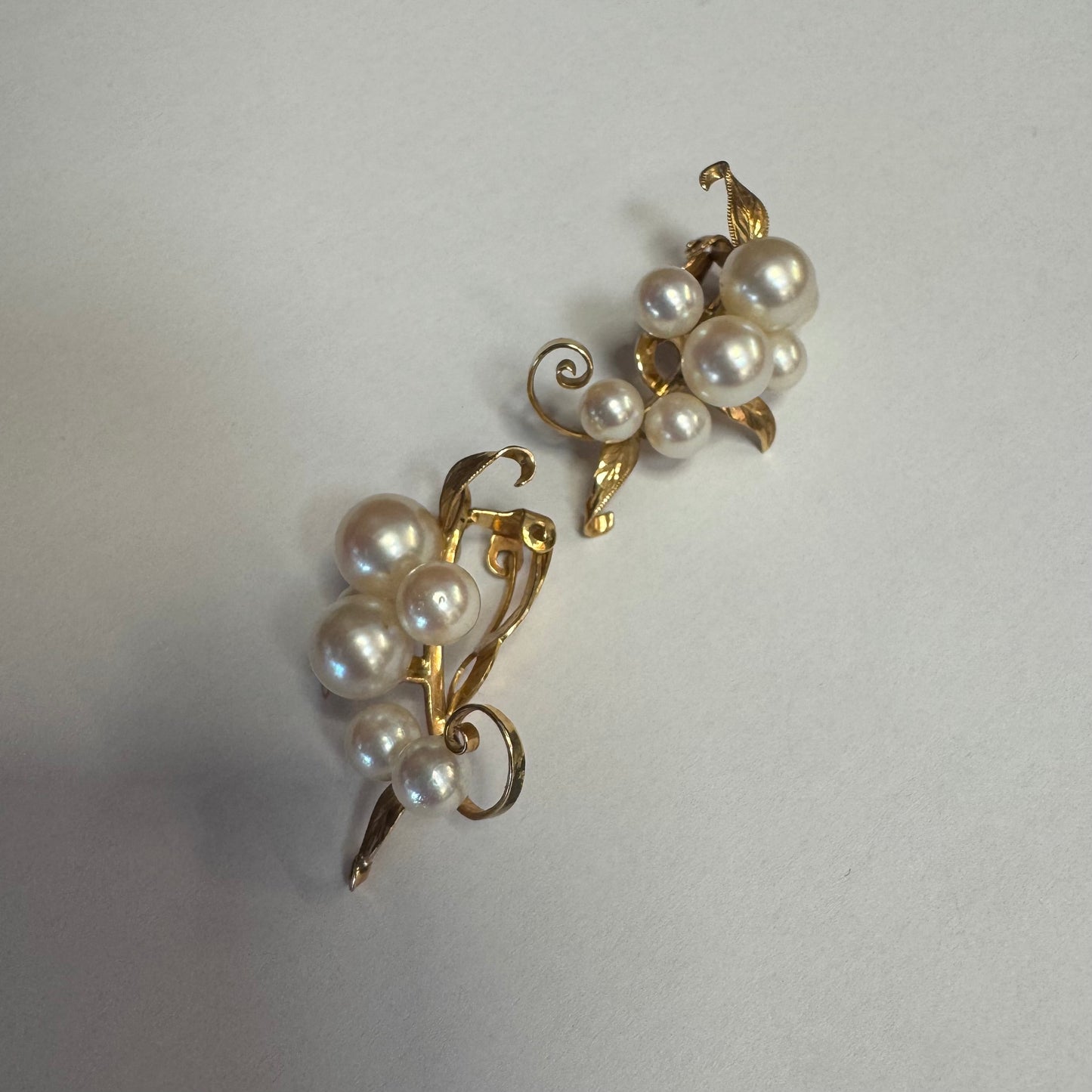 עגילי קליפס זהב 14 קראט, משובצים אשכול פנינים בגווני לבן-קרם.