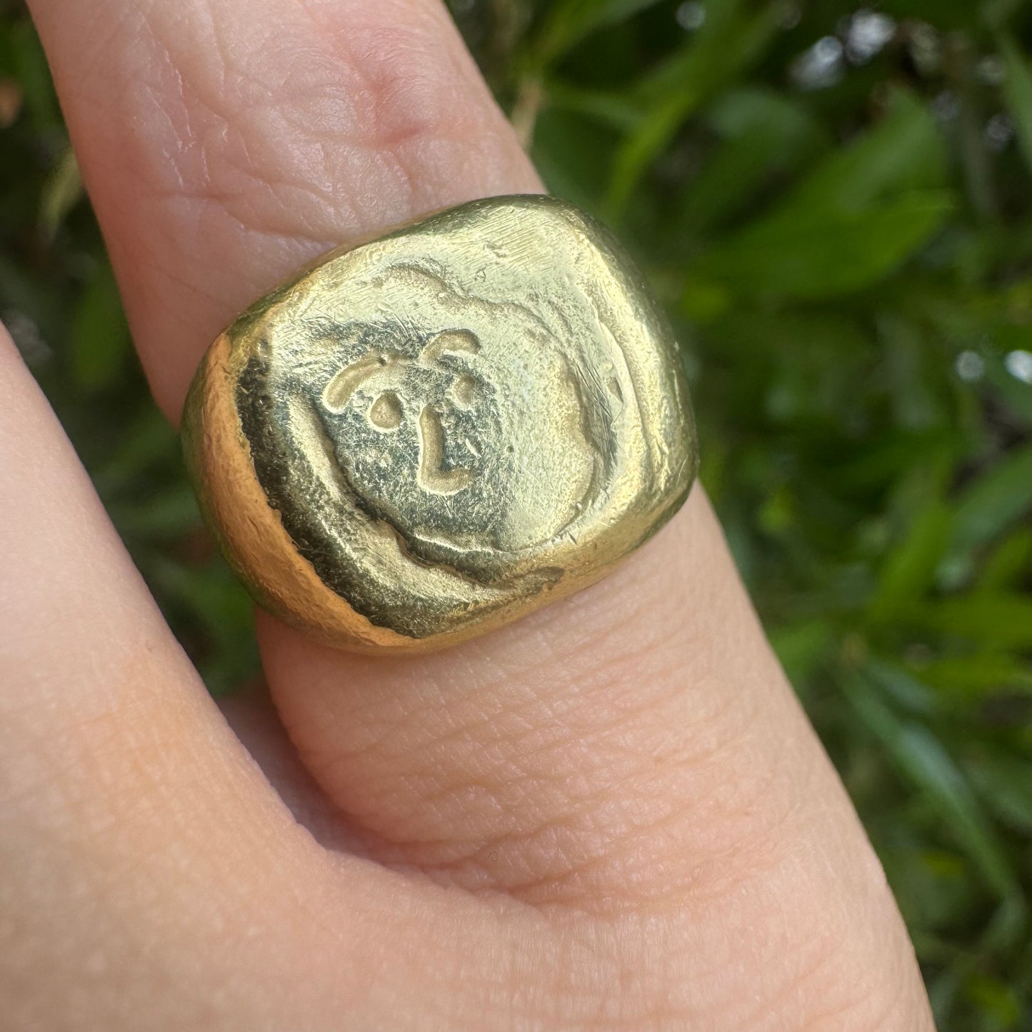 18K gold chunky gold ring with a rustic, organic finish, featuring an engraved abstract face motif at its center.