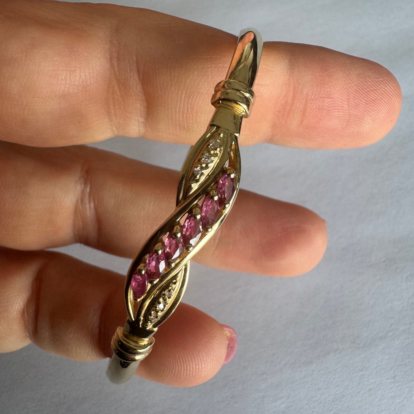 צמיד זהב צהוב 14 קראט משובץ אבני טורמלין בגוון ורוד-עמוק, בשילוב יהלומים המוסיפים ברק עדין.