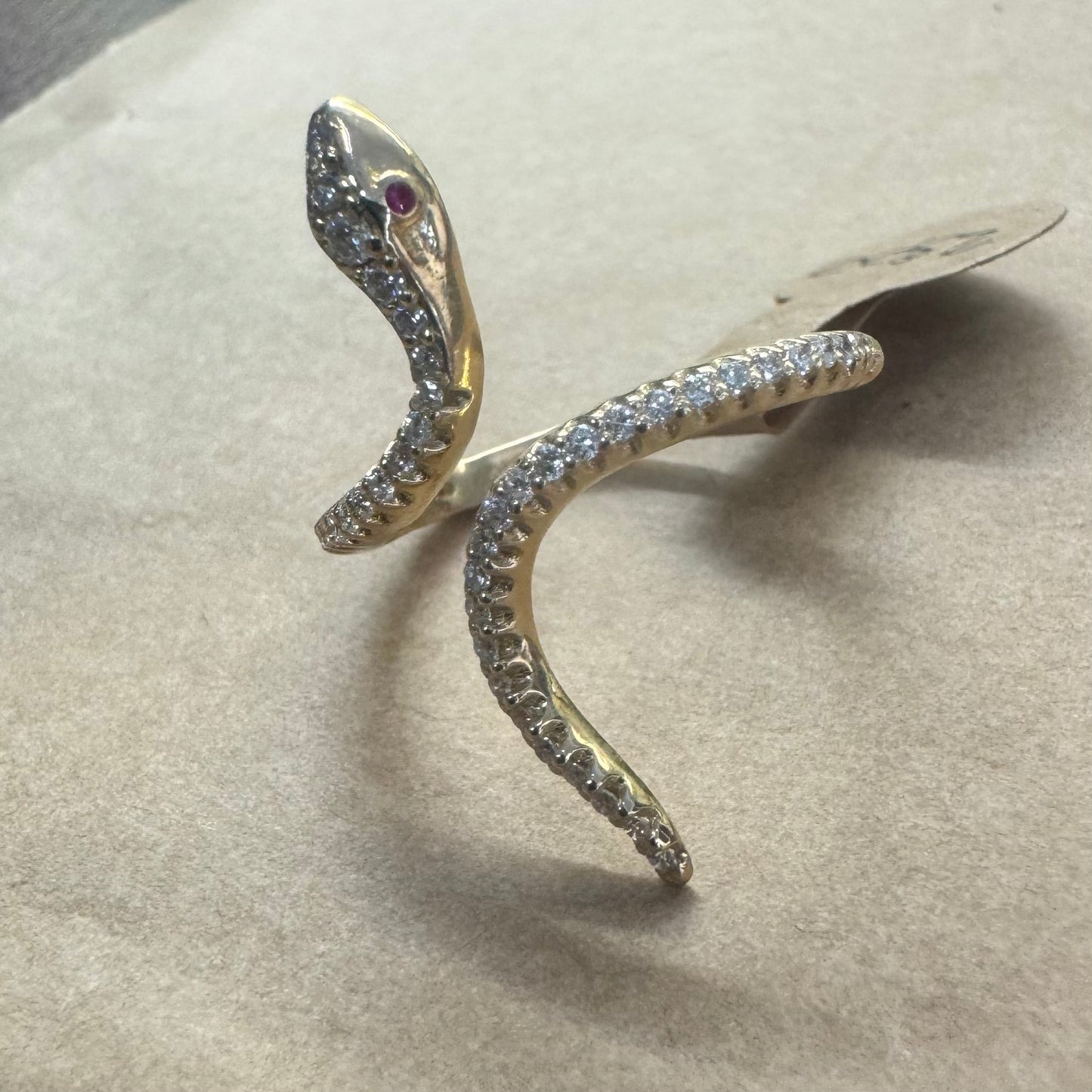 14K gold wrap-around snake ring, fully set with sparkling Diamonds along its body and head, finished with Rubies eyes