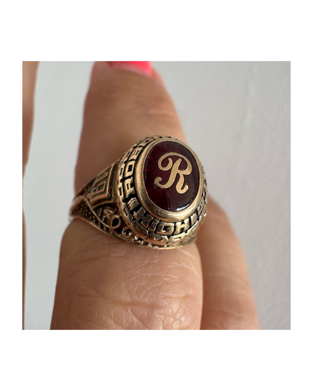 10K gold class ring featuring a rich red center stone engraved with the letter “R”.