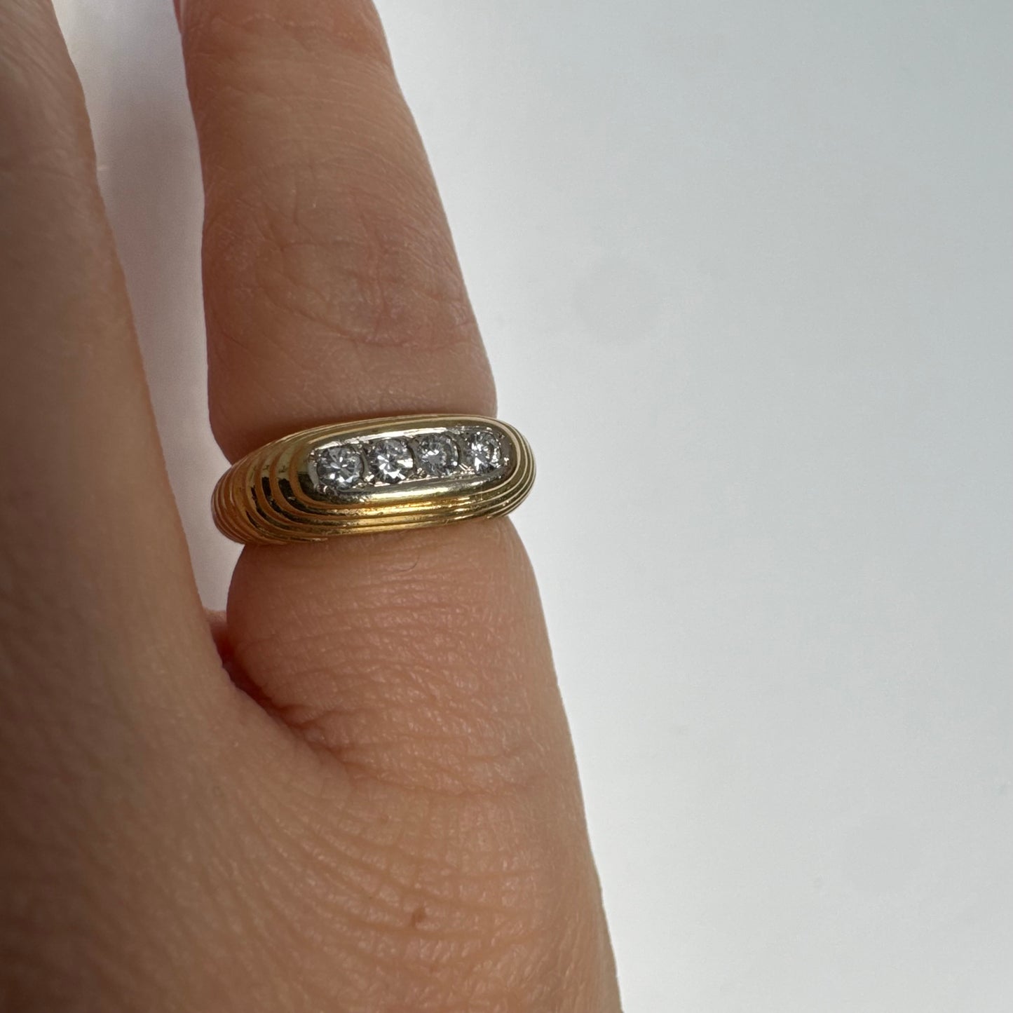 14K gold elongated oval ring set with five round Diamonds in a channel setting.