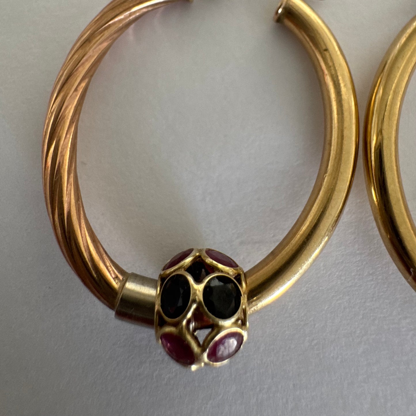 10K gold hoop earrings with a twisted design, set with pink and green Tourmaline.
