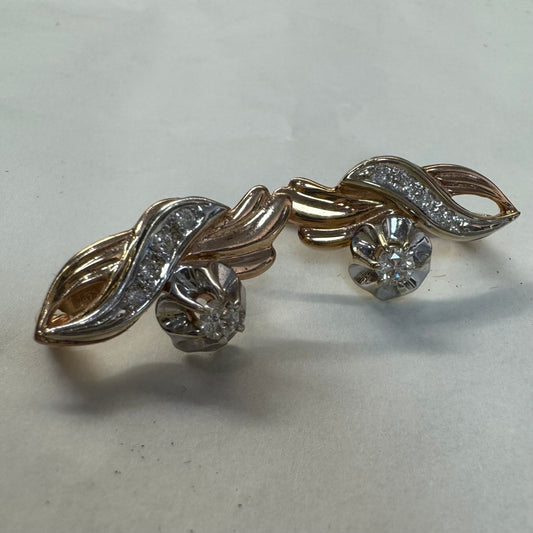 עגילי זהב 14 קראט בעיצוב מתעגל ואלגנטי המשובצים יהלומים נוצצים .