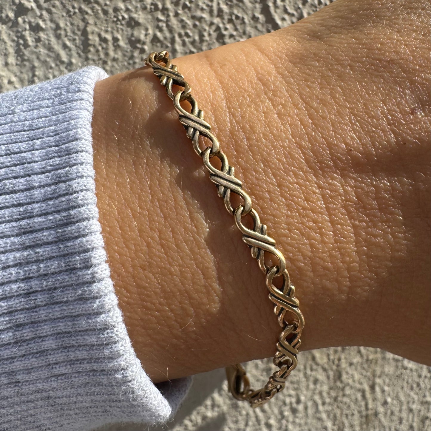 צמיד זהב 14 קראט, בעיצוב חוליות עדין ומסולסל.