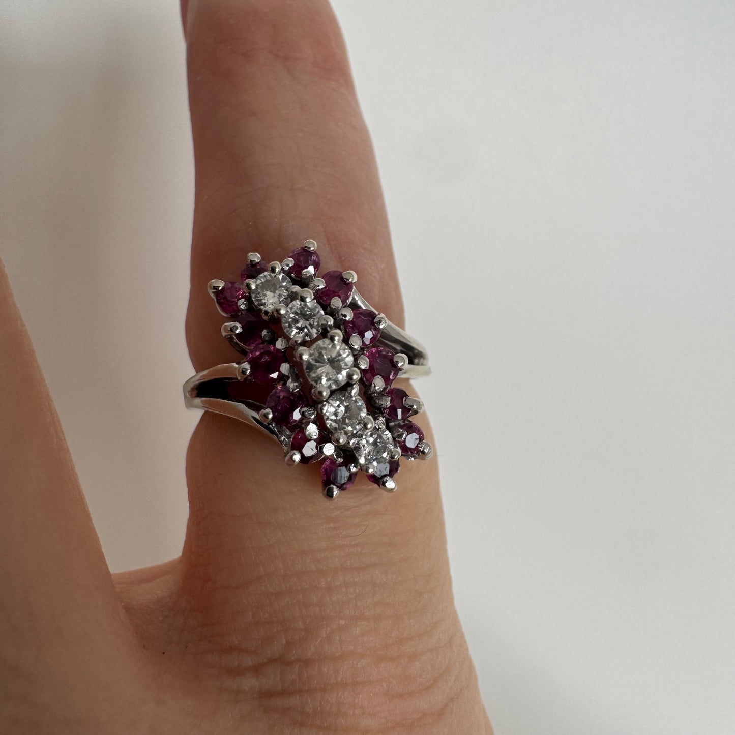 14K gold ring set with a rich cluster of deep raspberry-toned Rubies, centered by a vertical row of sparkling white Diamonds.