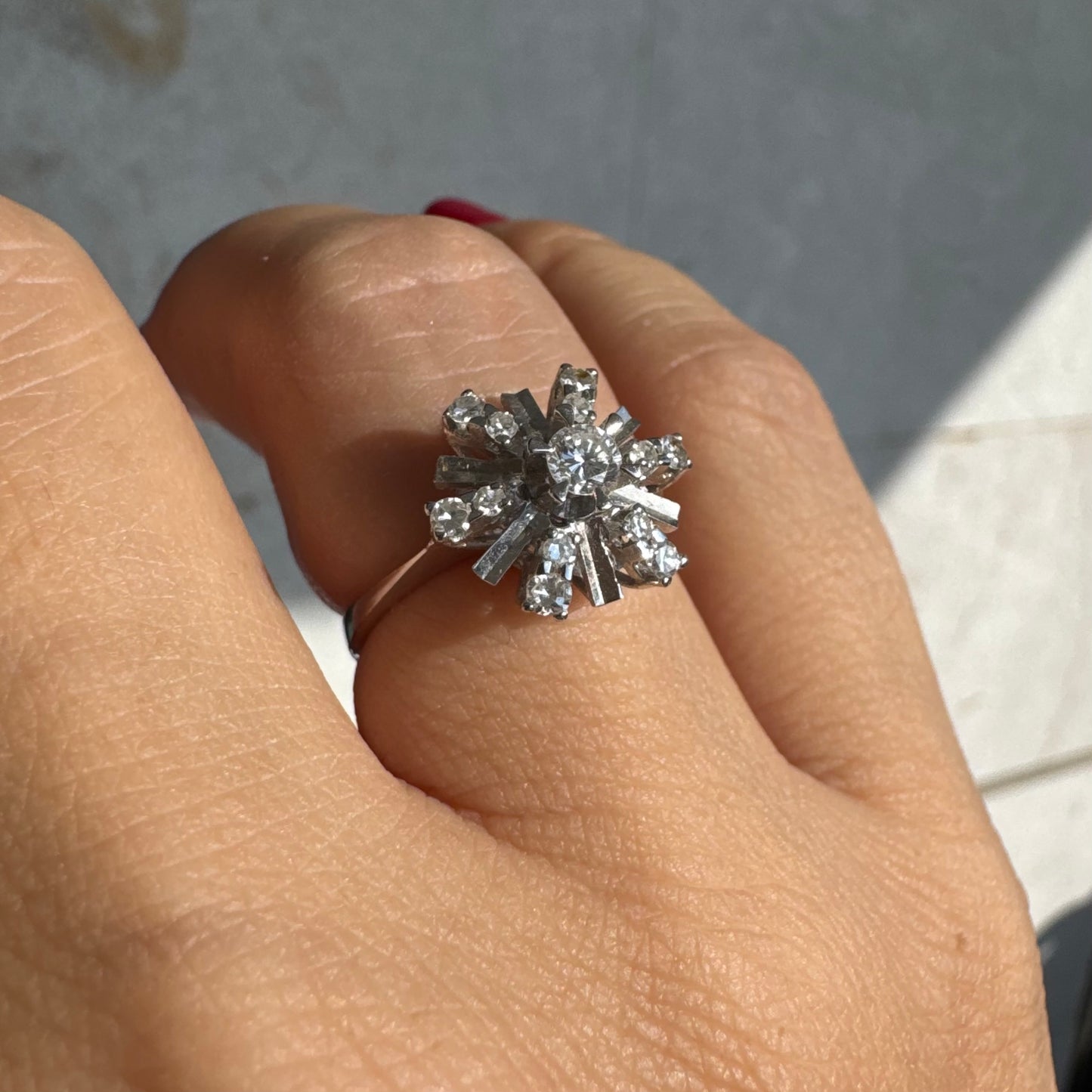 טבעת זהב לבן 18 קראט בעיצוב קרני שמש מרהיב, משובצת יהלומים הלוכדים את האור מכל כיוון. 