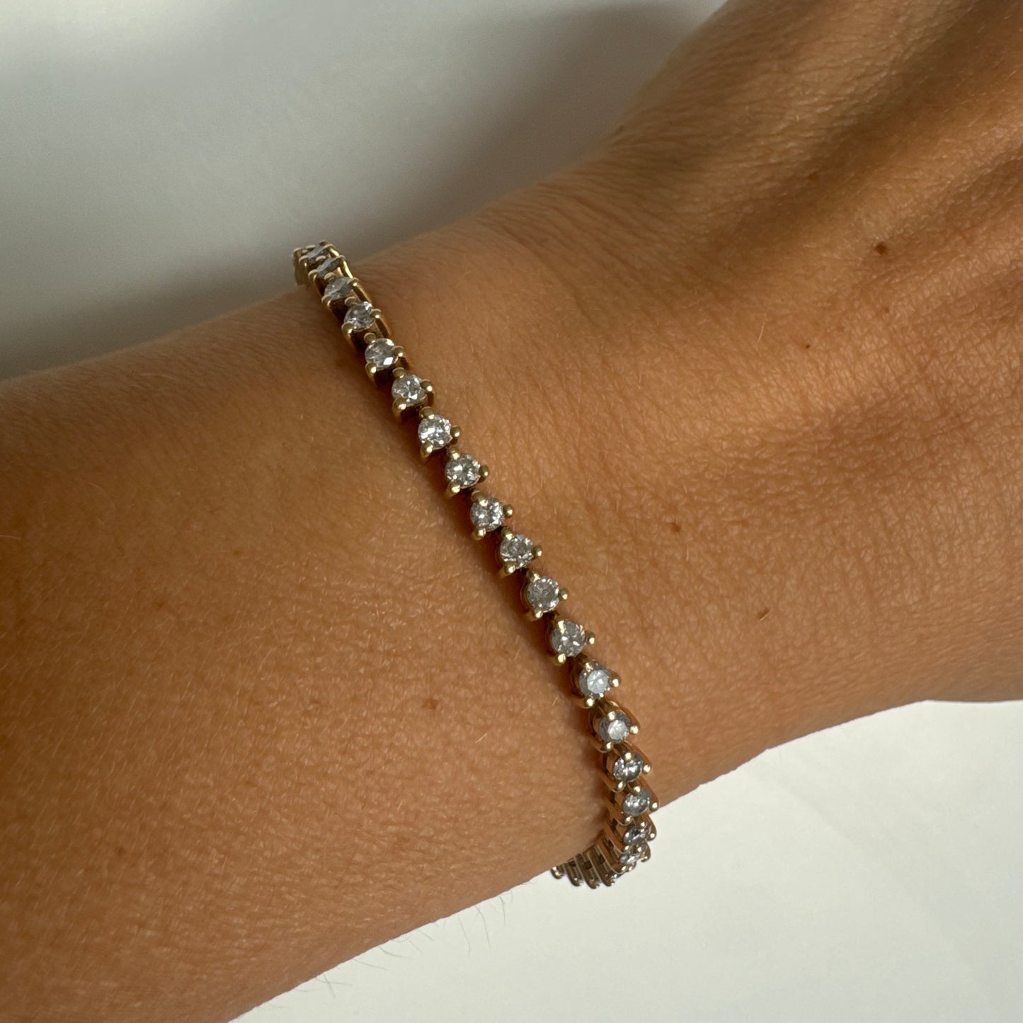 14K gold tennis bracelet set with a continuous line of round Diamonds, creating a delicate and elegant sparkle.