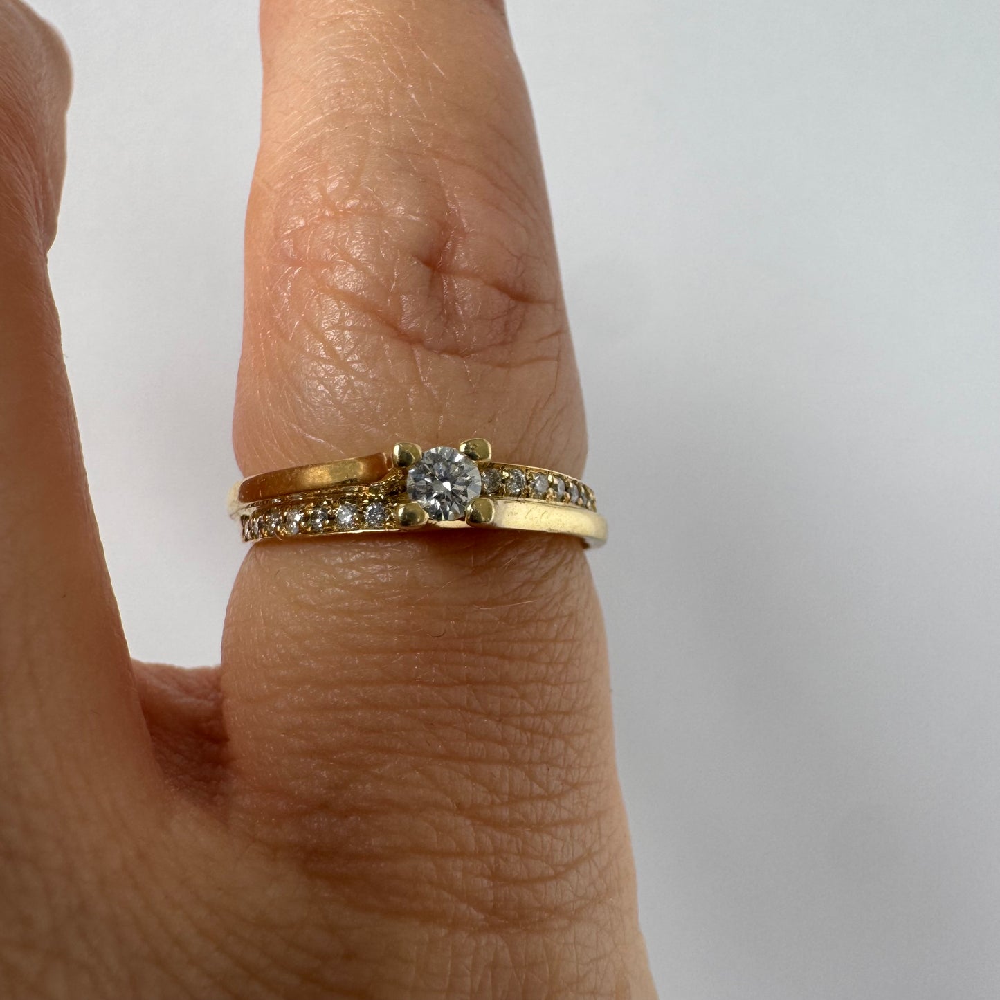 14K yellow gold ring set with a round brilliant-cut diamond and a pavé diamond band ￼