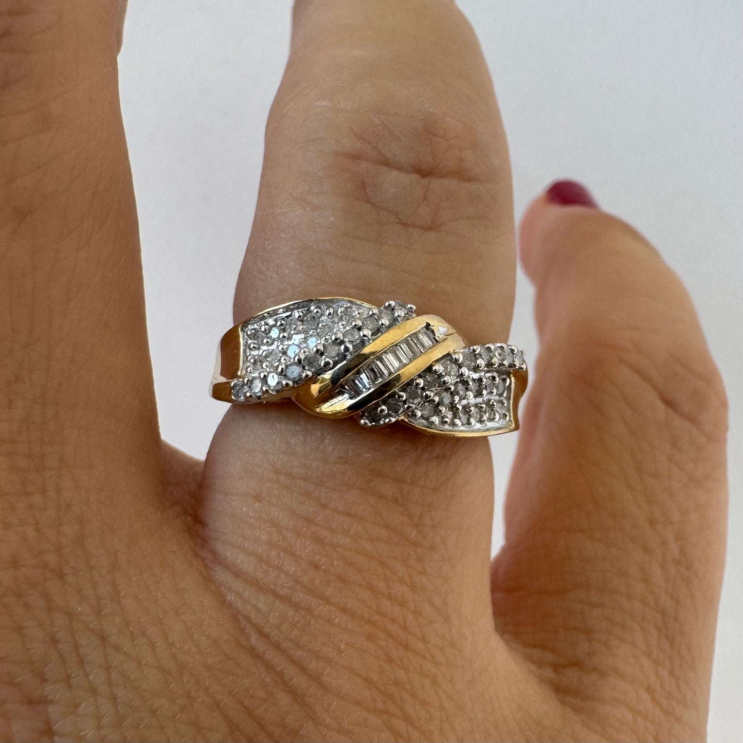 10K gold ring set with round-cut Diamonds and a central row of baguette Diamonds.