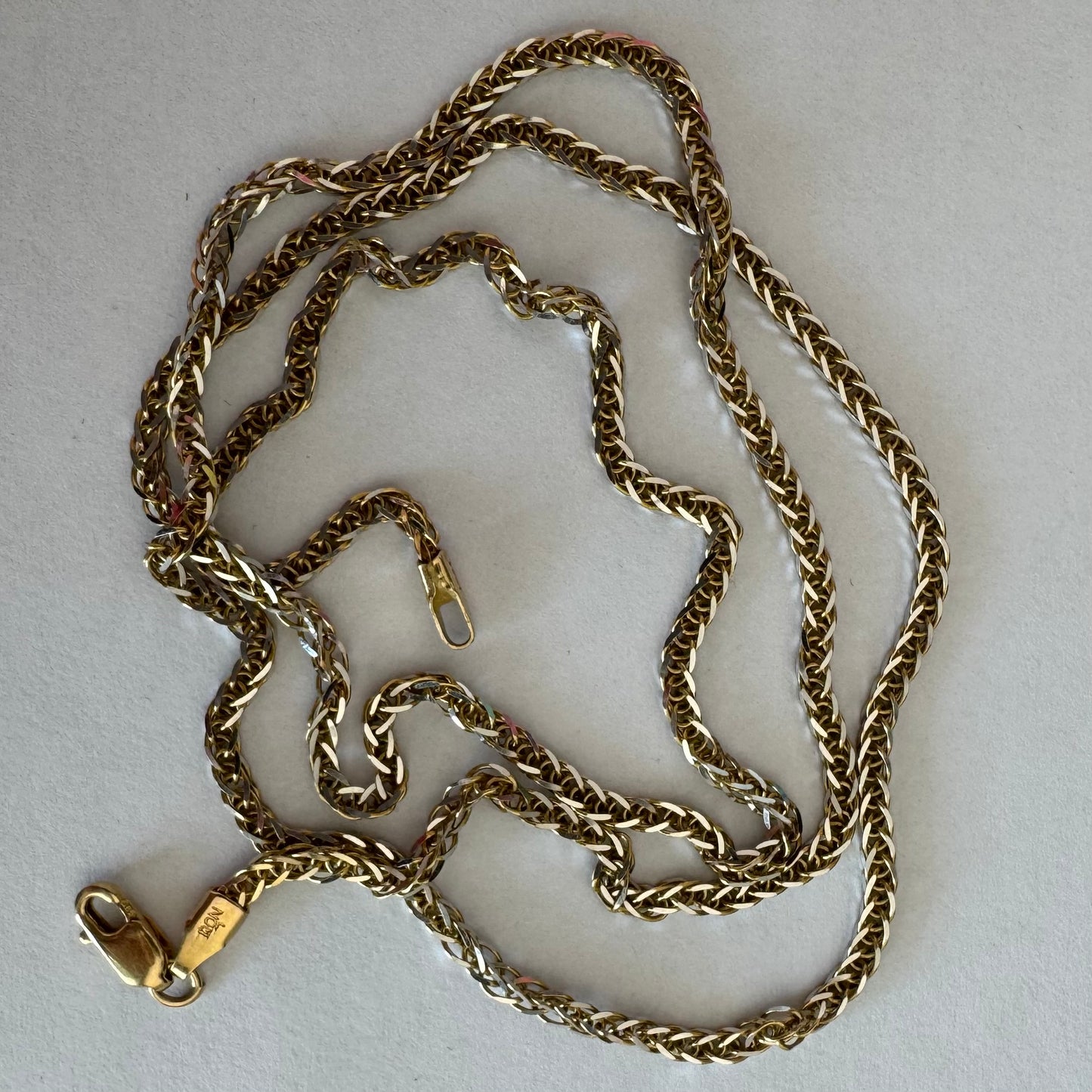 שרשרת זהב צהוב 14 קראט בעיצוב חוליות קלועות היוצרות מראה עשיר ומלא ברק.