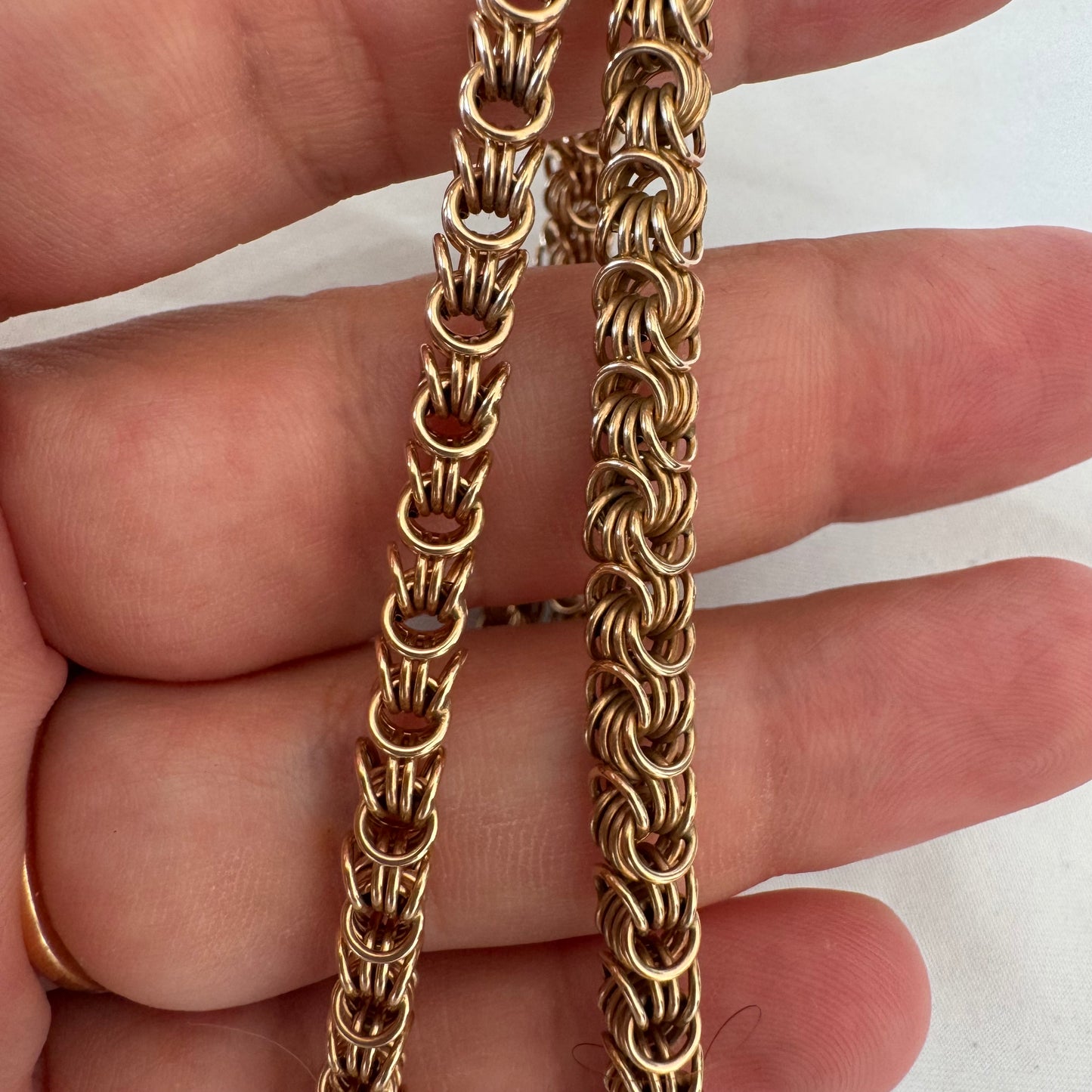 14K gold necklace featuring intricate, interwoven links that create a rich and textured look.
