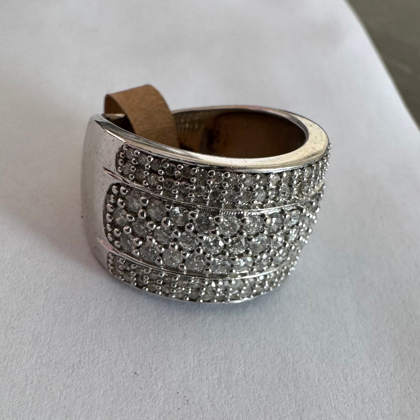 טבעת זהב לבן 18 קראט בעיצוב רחב ומרשים, משובצת יהלומים בשיבוץ פאווה צפוף המעניק ברק עשיר ונוכחות יוקרתית מכל זווית.