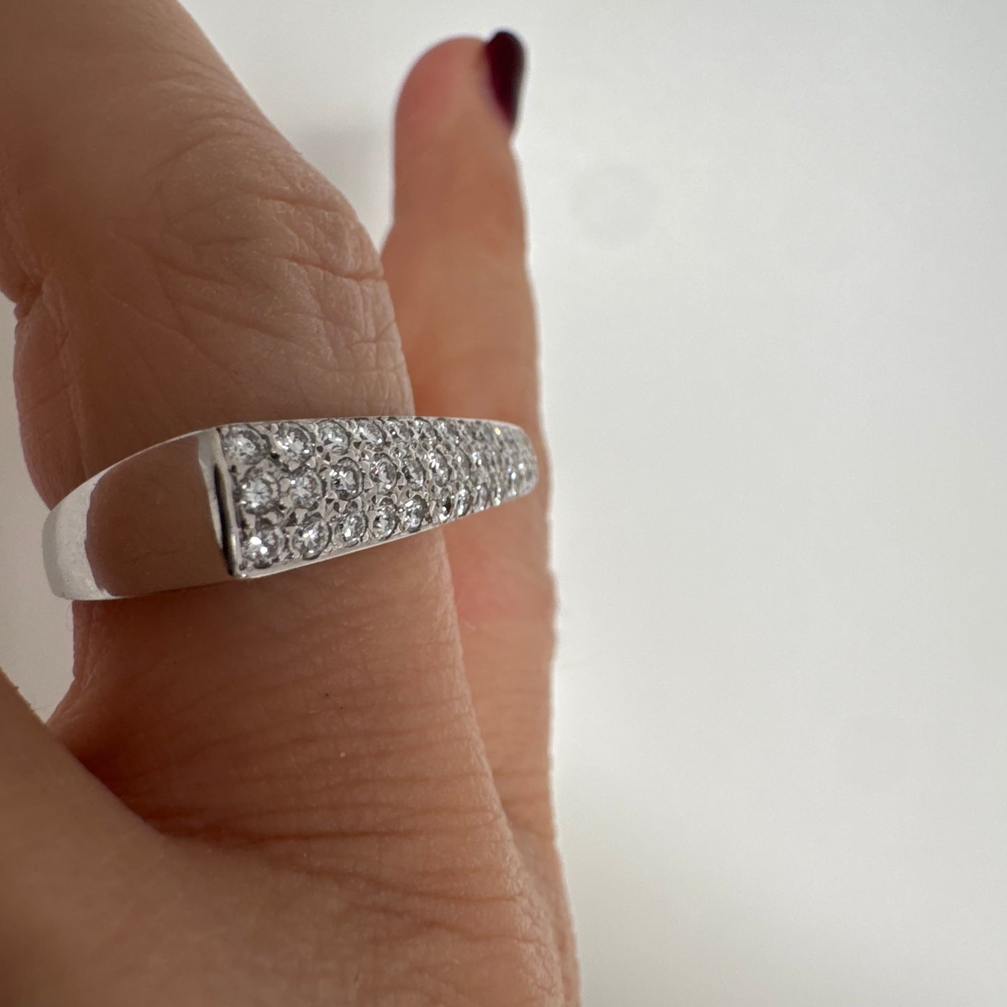 18K white gold band fully set with pavé diamonds across the surface.