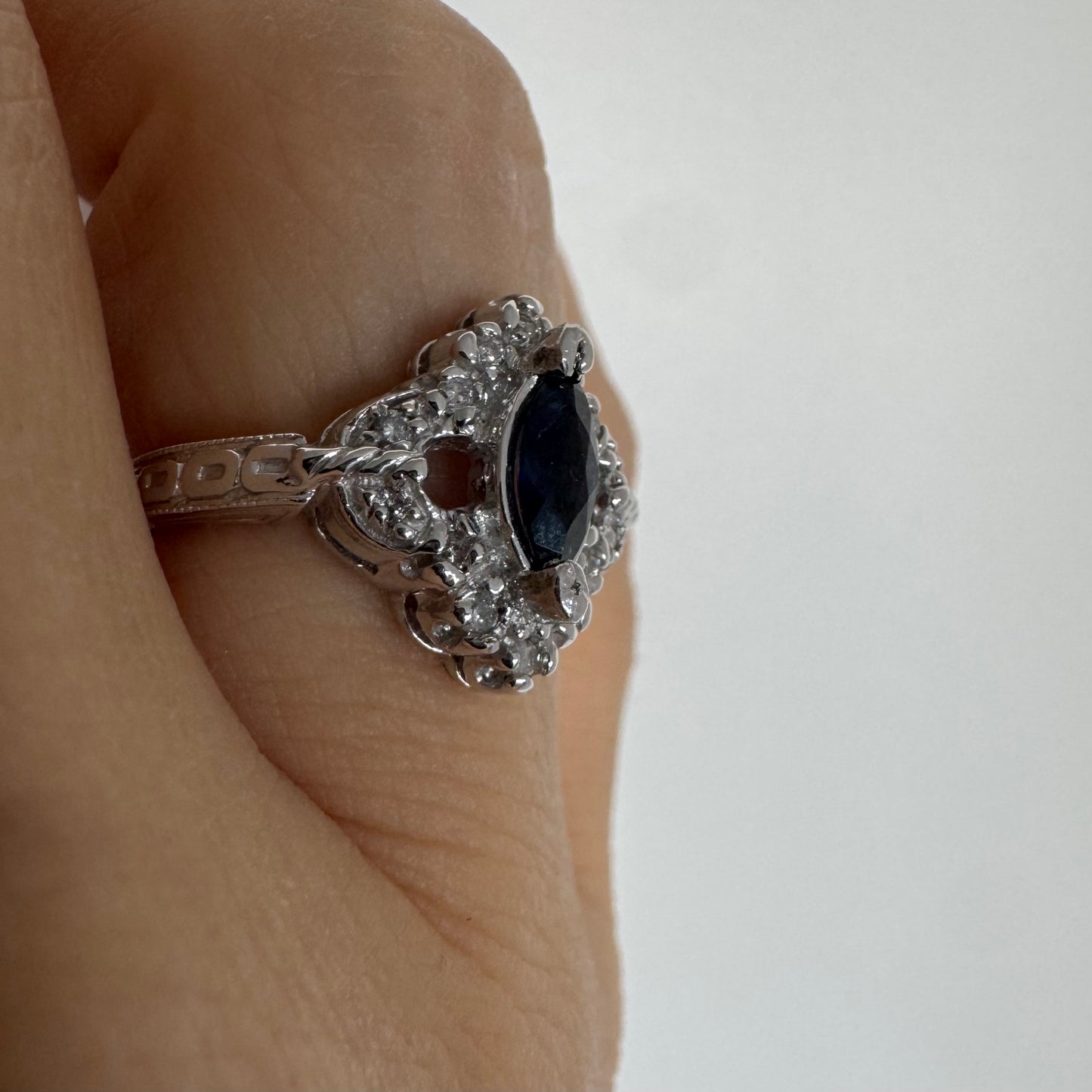 טבעת זהב לבן 14 קראט משובצת אבן ספיר בצבע כחול כהה בחיתוך מרקיזה ומסביב משובצים יהלומים