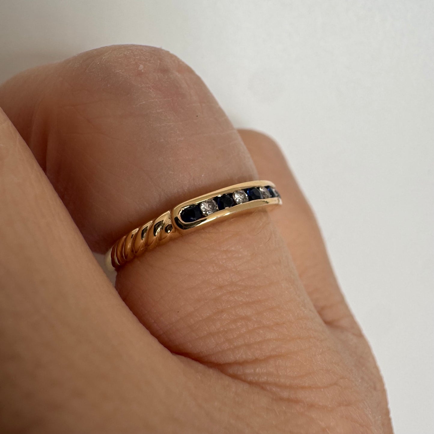 18K gold ring featuring a refined channel setting of deep blue Sapphires accented with Diamonds.