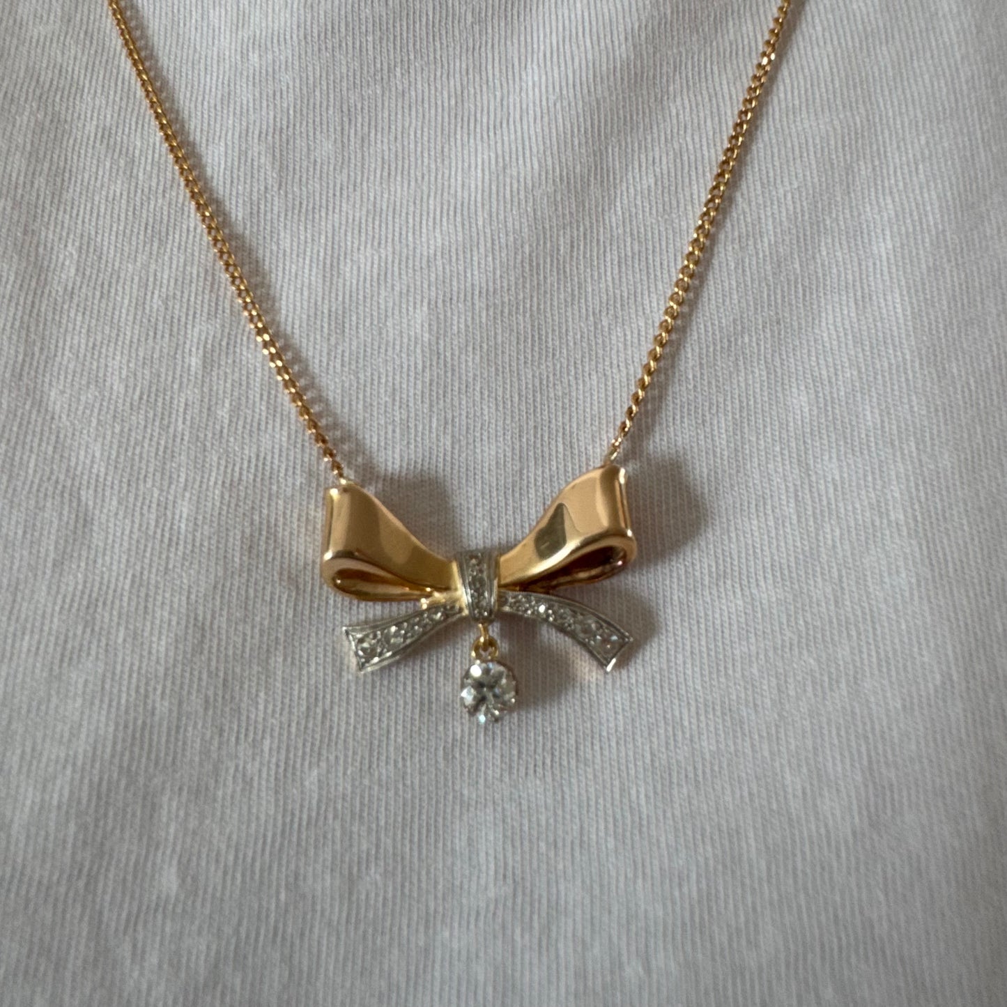 שרשרת זהב 18 קראט עם תליון בצורת סרט קלאסי משובץ יהלומים ונושא יהלום מרכזי תלוי שמוסיף נגיעה של זוהר ואלגנטיות