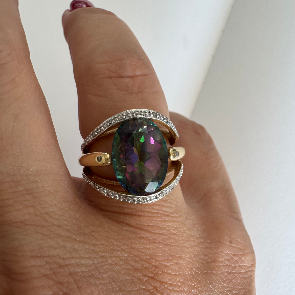 14K gold ring set with an oval Mystic Topaz