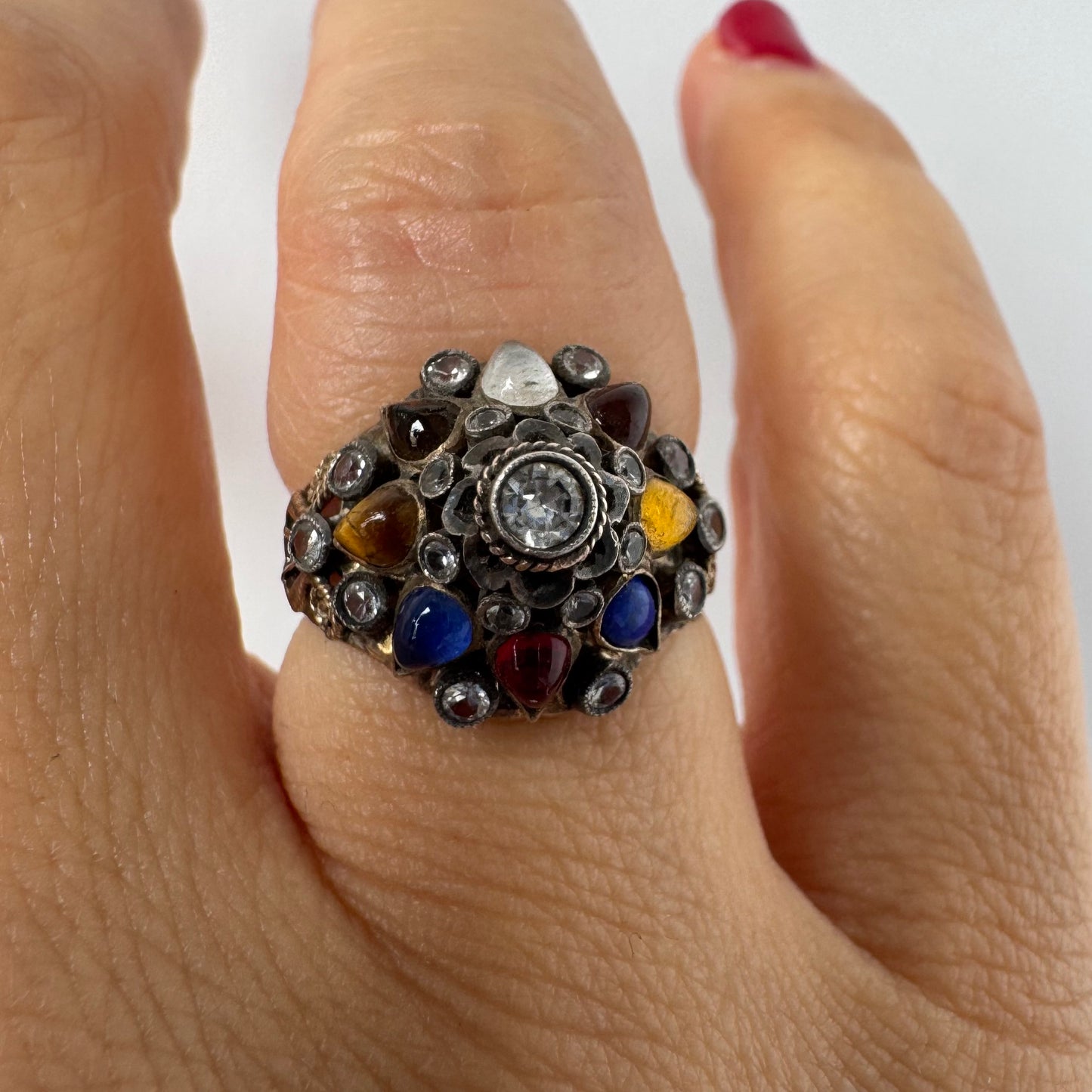 14K gold ring set with a central transparent gemstone surrounded by a vibrant mosaic of colorful gemstones -set in an ornate, handcrafted design