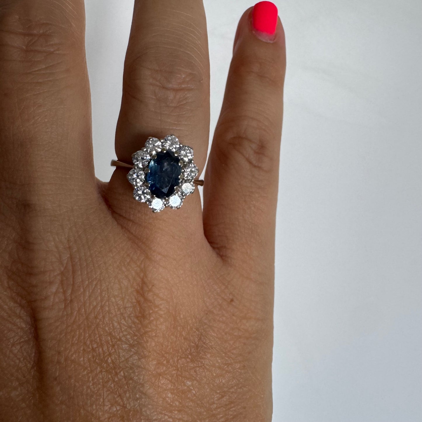 18K gold ring featuring a deep blue Sapphire at its center, surrounded by a sparkling halo of Diamonds
