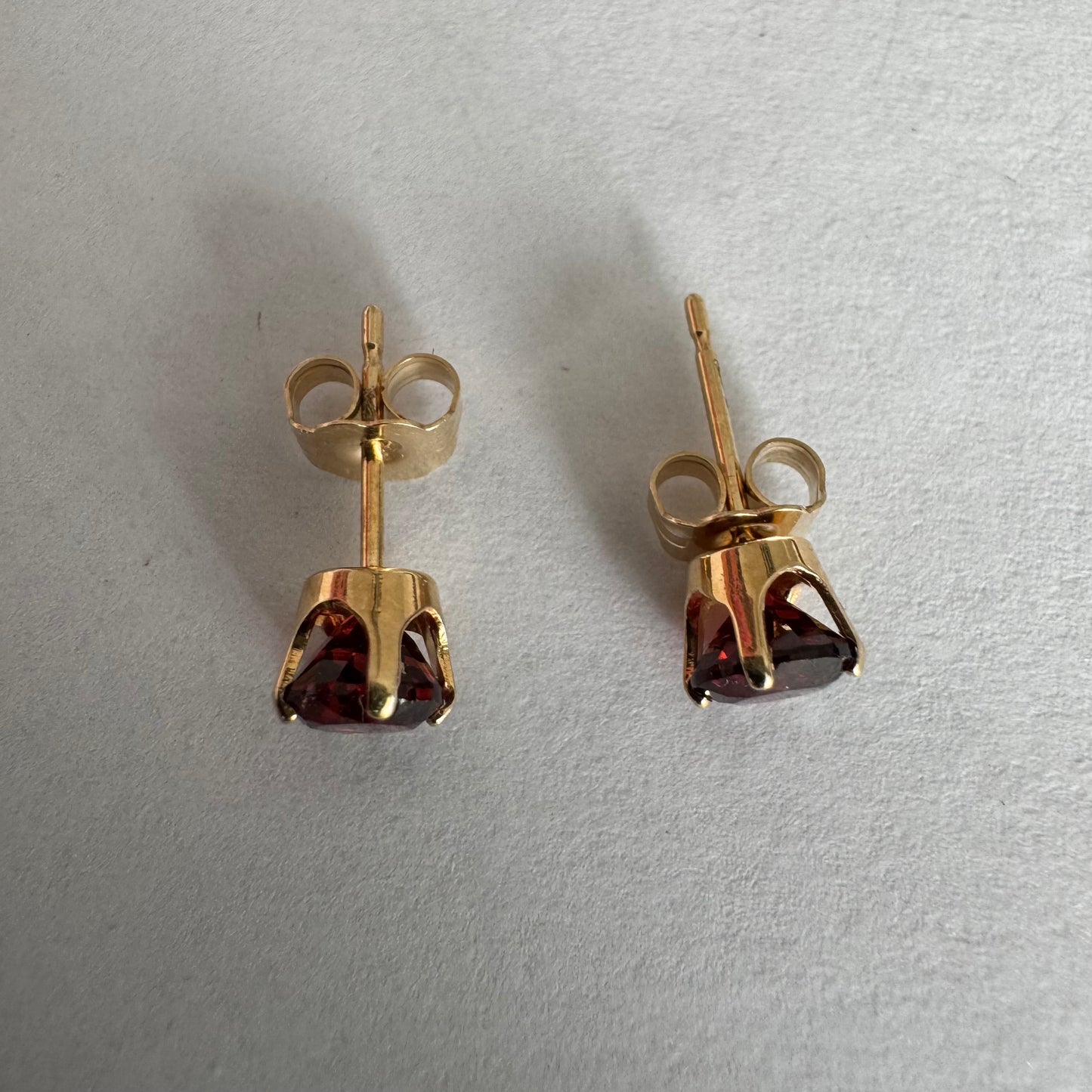 עגילי זהב 14 קראט משובצים אבני גרנט בגוון אדום יין עמוק.