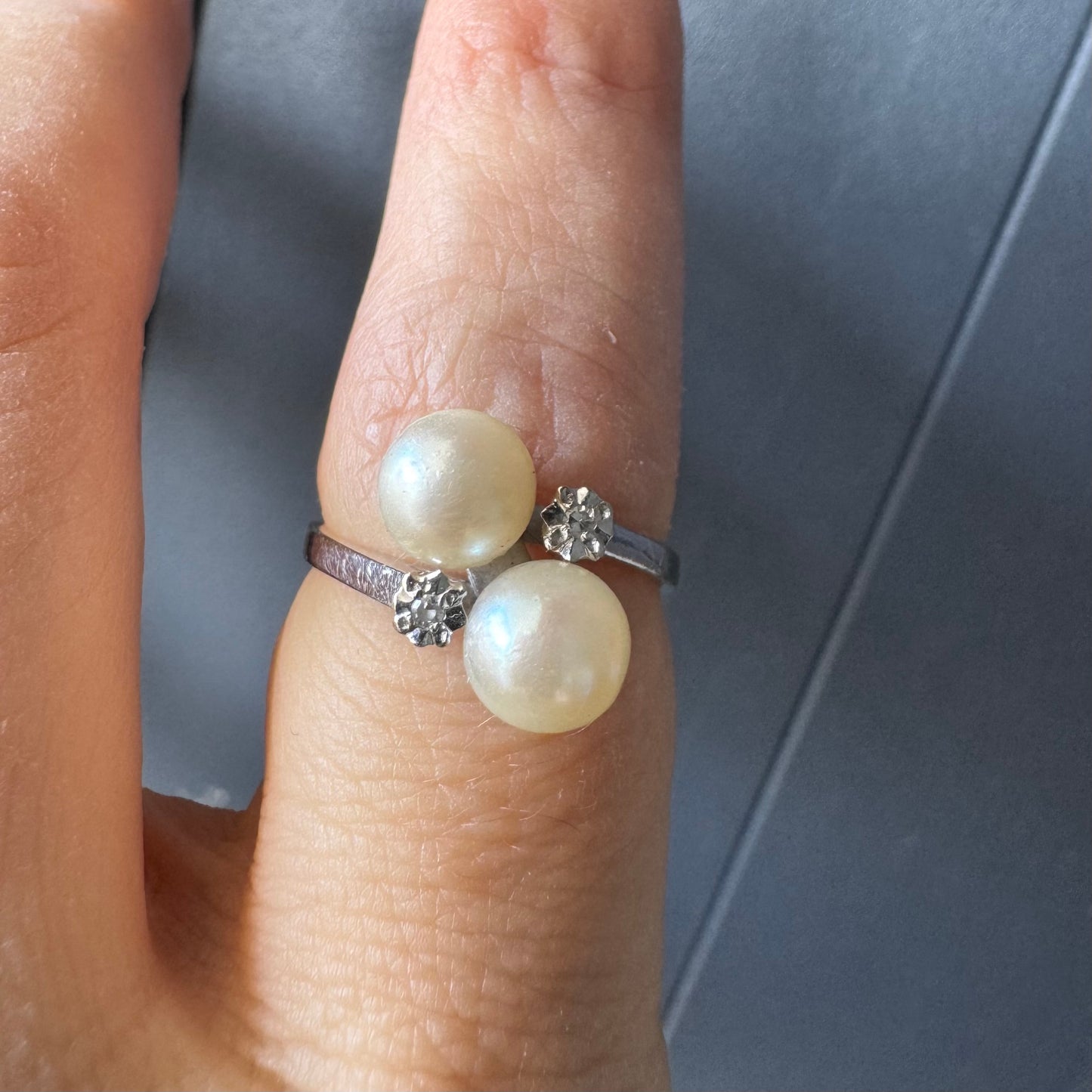 18K gold ring featuring a refined open design set with two luminous white Pearls and accented with two sparkling Diamonds